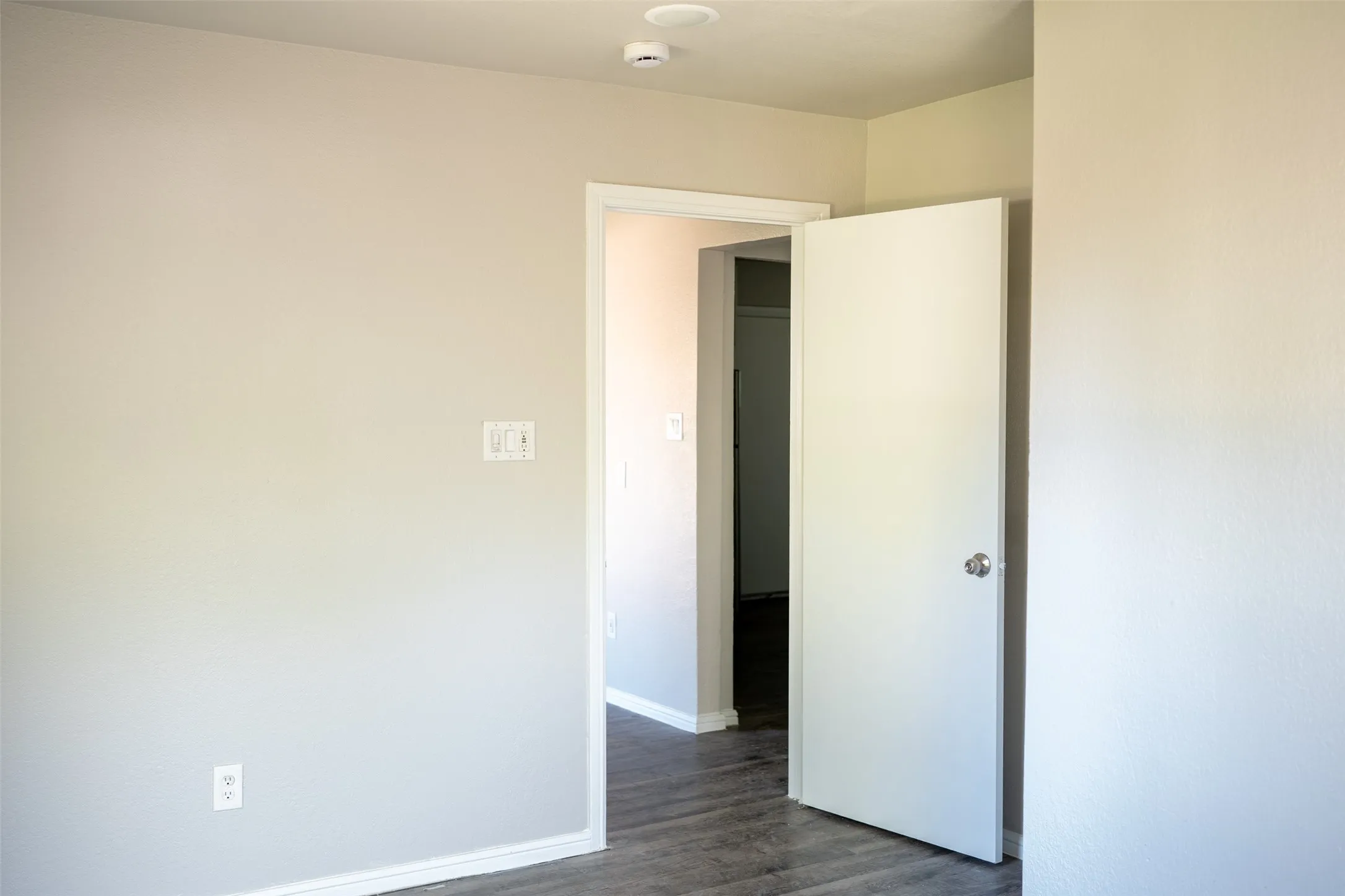 Unfurnished bedroom featuring baseboards and dark wood finished floors