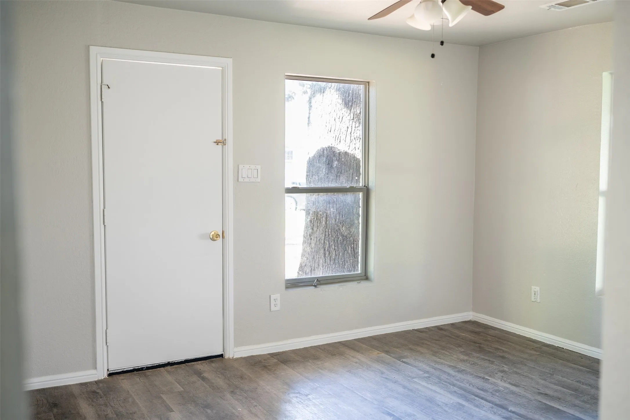Unfurnished room with wood finished floors and a ceiling fan