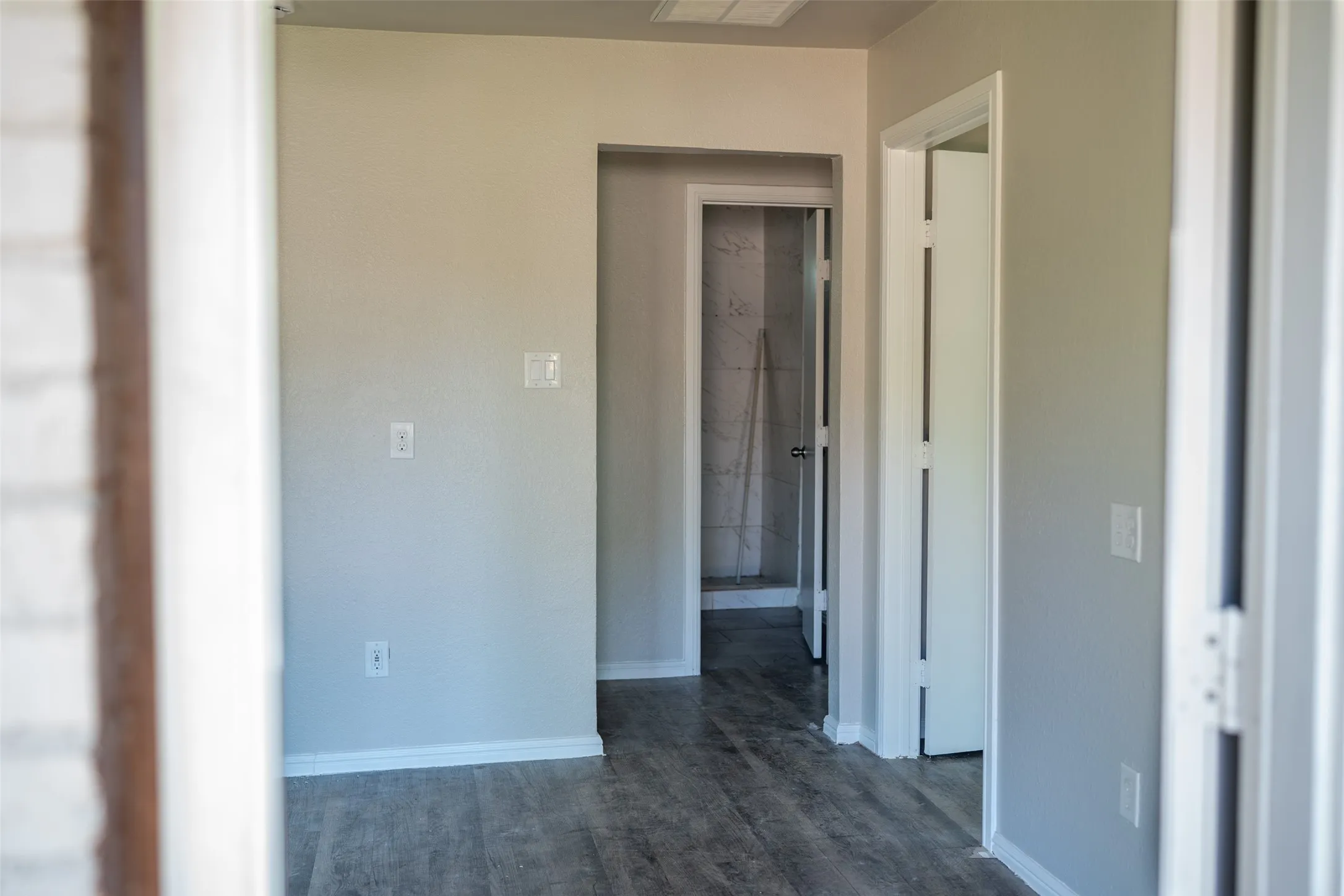 Hall with baseboards and dark wood-style flooring