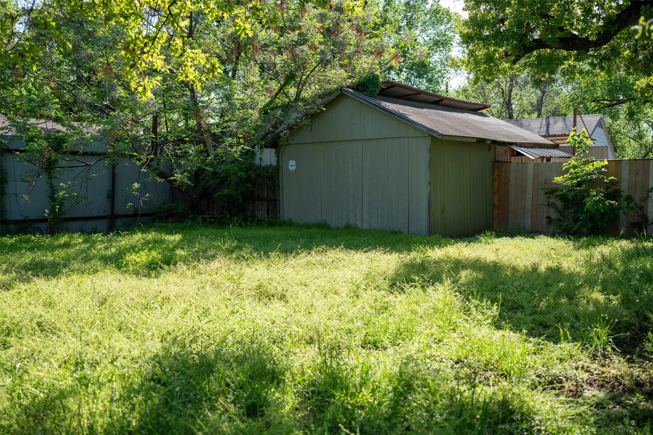 Fenced backyard featuring an outdoor structure