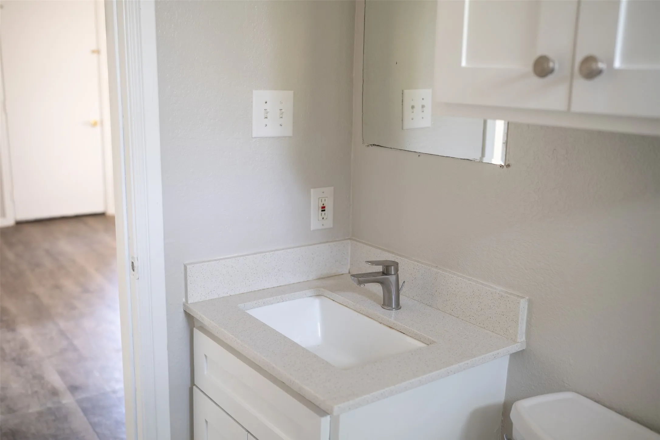 Bathroom featuring vanity, dark wood finished floors, and a textured wall