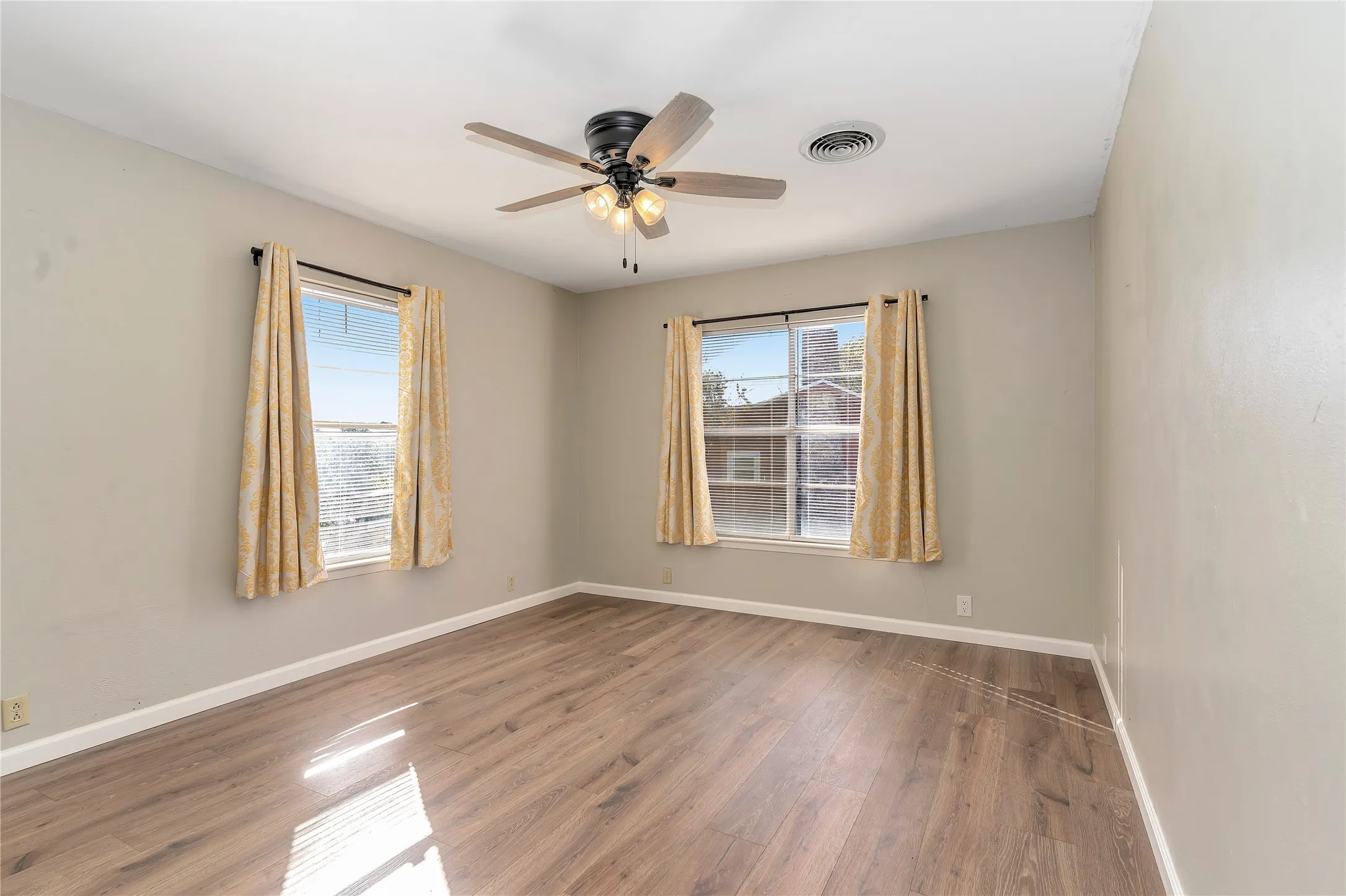 Empty room featuring wood finished floors and a ceiling fan