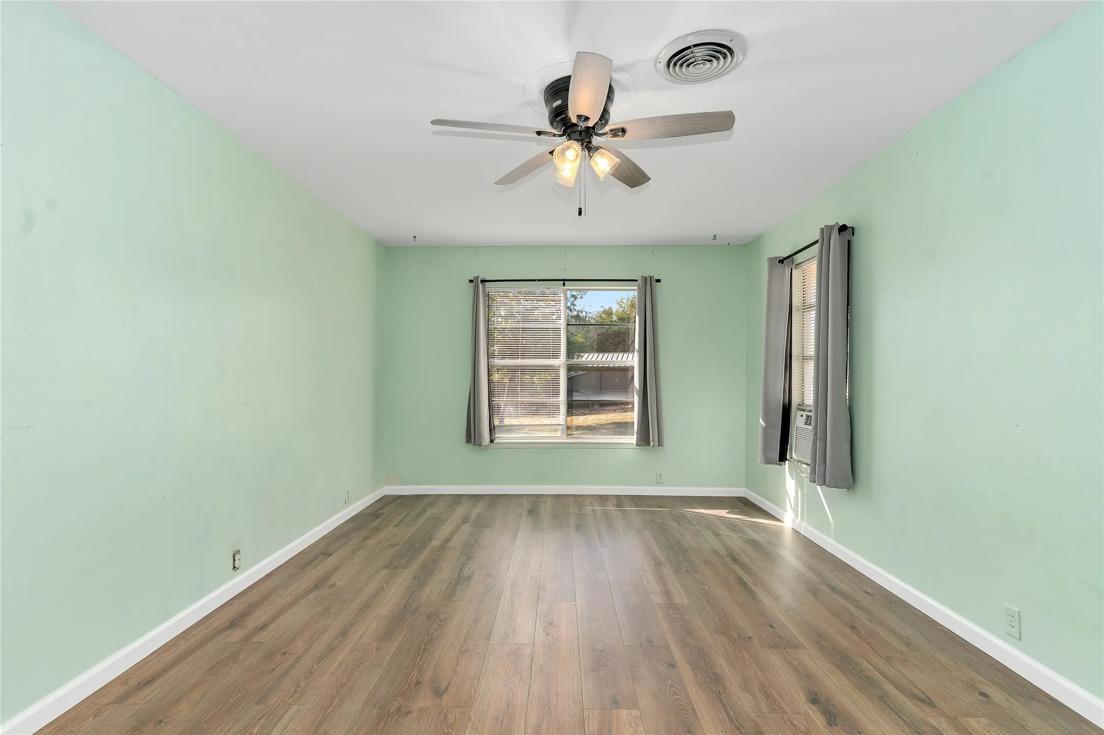 Spare room with dark wood-style floors and a ceiling fan