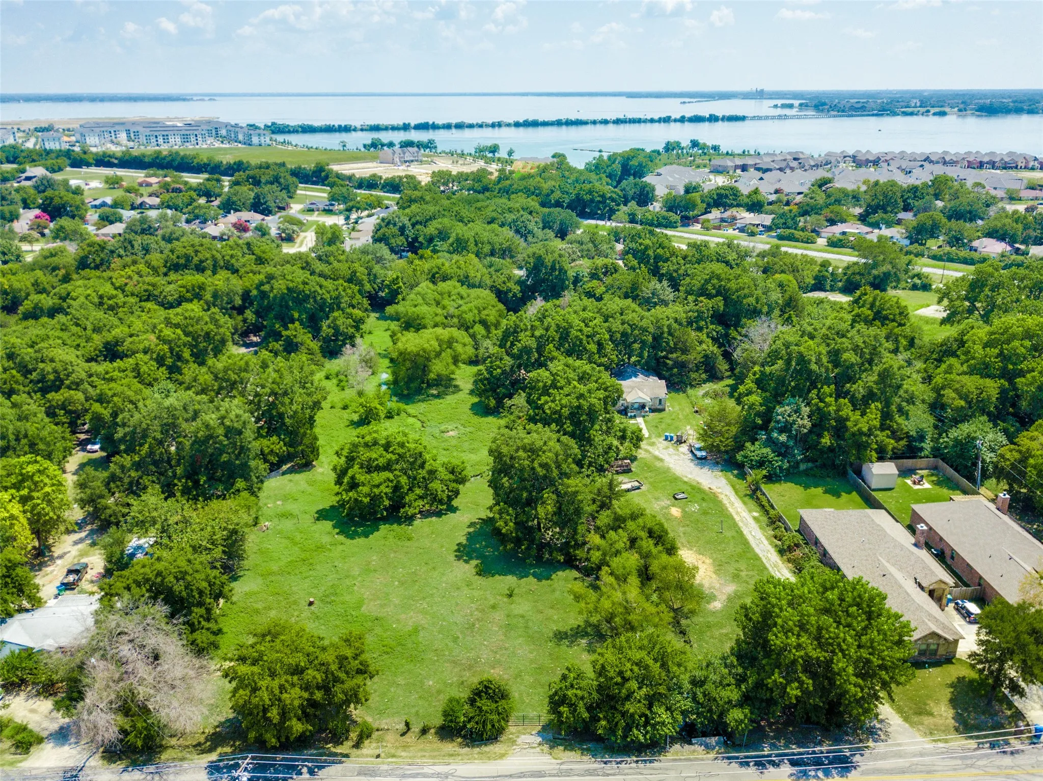 View from north. Road leading to the house amongst the trees is the property. Lake Ray Hubbard and Sapphire Bay in the top left of picture.