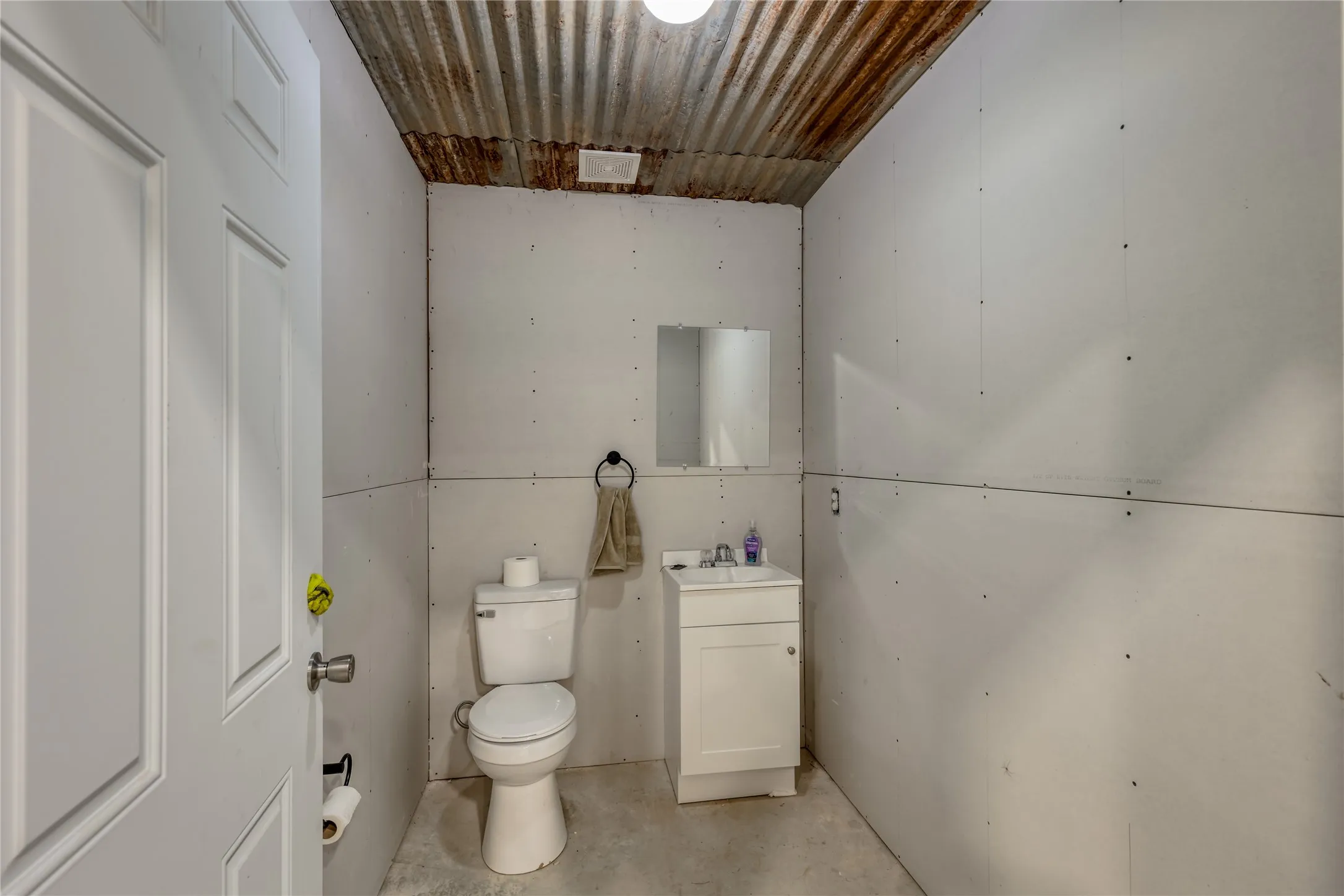 Bathroom with vanity and unfinished concrete flooring
