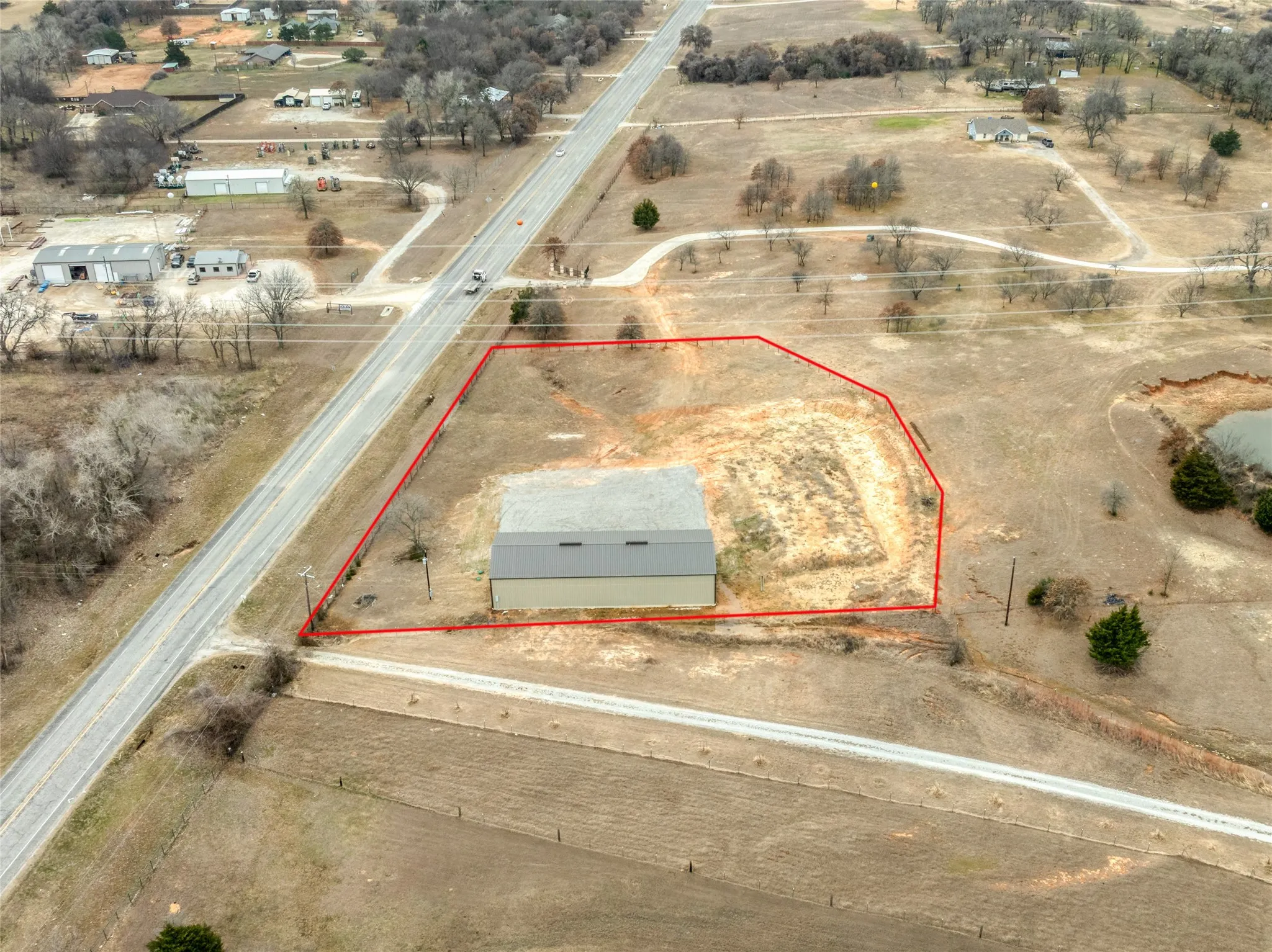 Aerial view of sparsely populated area with property parcel outlined