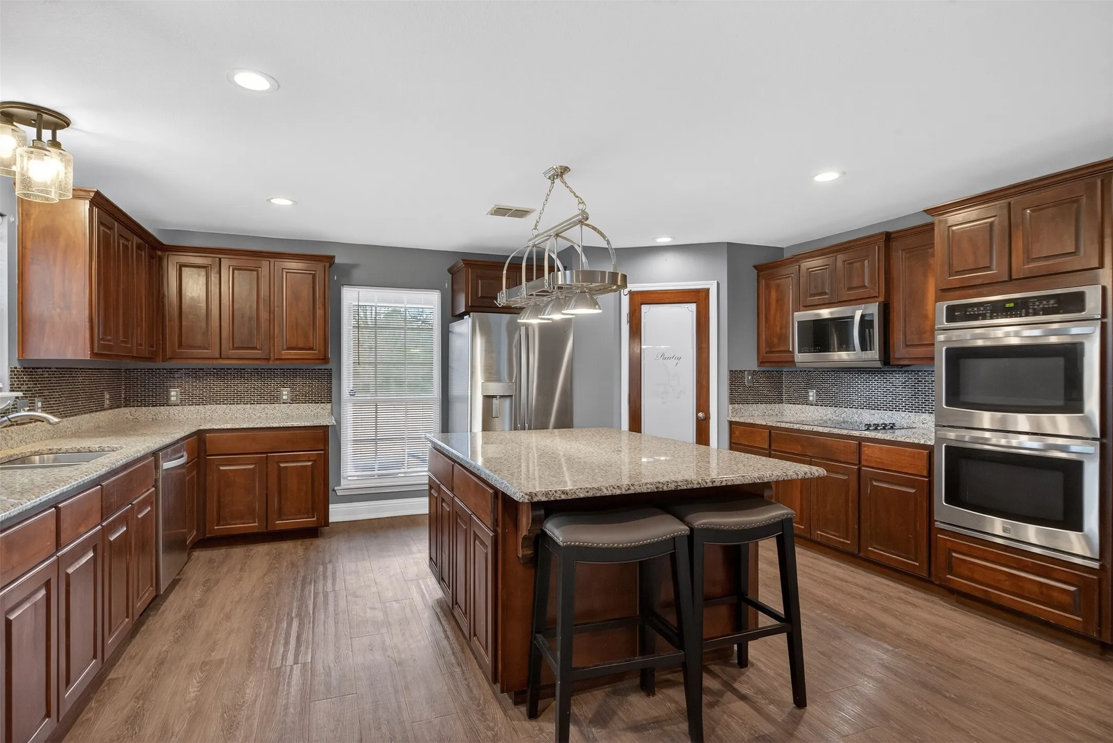 Kitchen with tasteful backsplash, stainless steel appliances, a breakfast bar, and light stone counters