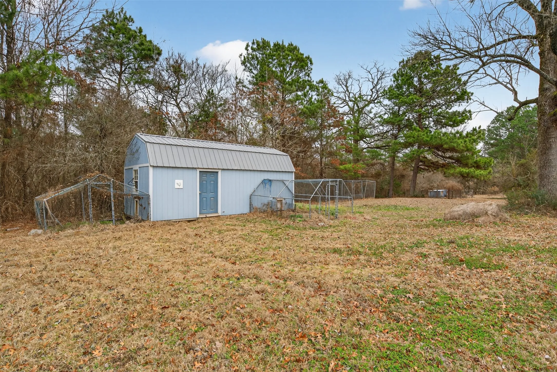 View of yard featuring an outdoor structure and view of wooded area