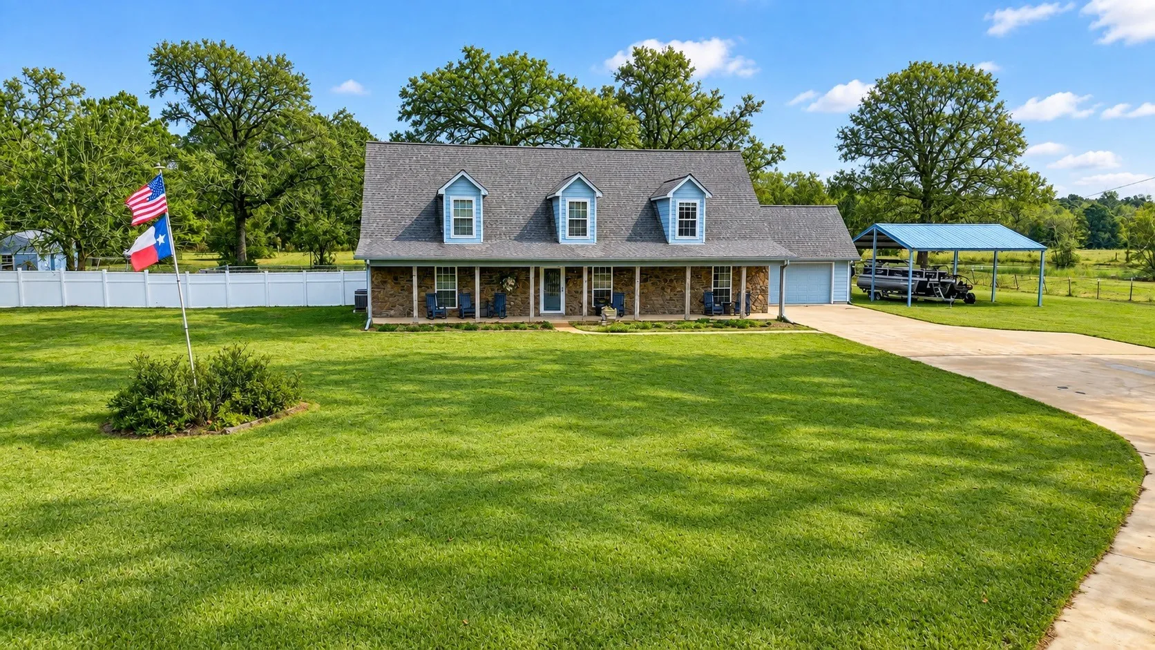 Stone and siding exterior with a covered porch, dormer windows, and an attached two-car garage
