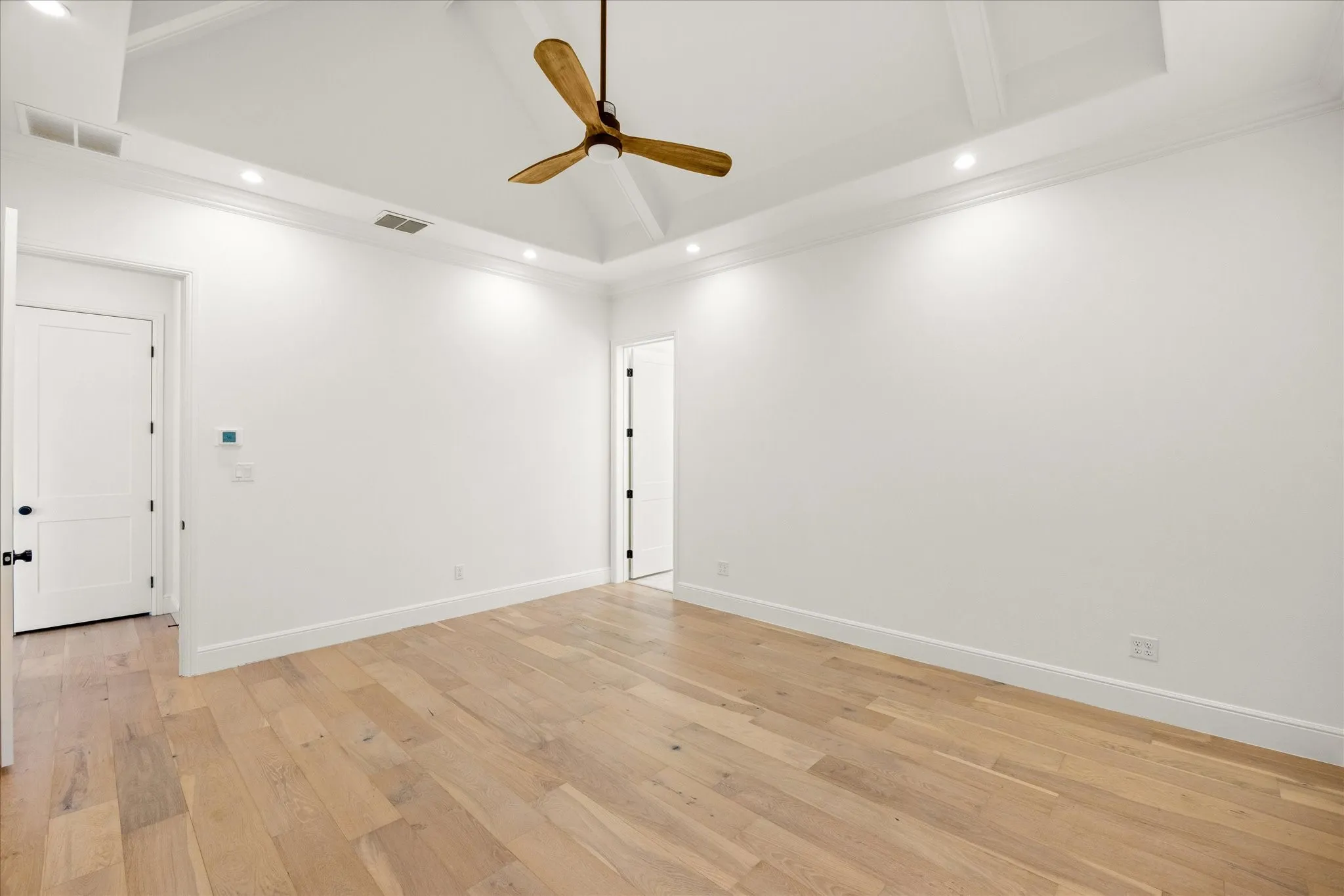 Unfurnished room featuring recessed lighting, a towering ceiling, a ceiling fan, light wood-type flooring, and ornamental molding