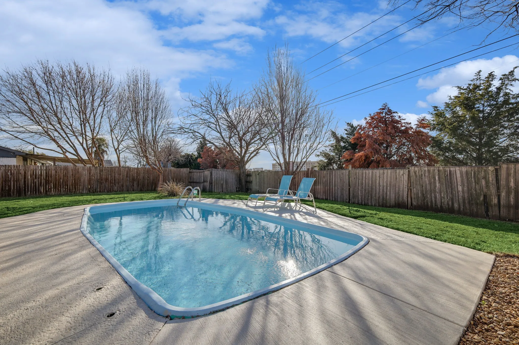 View of swimming pool featuring a patio area and a yard