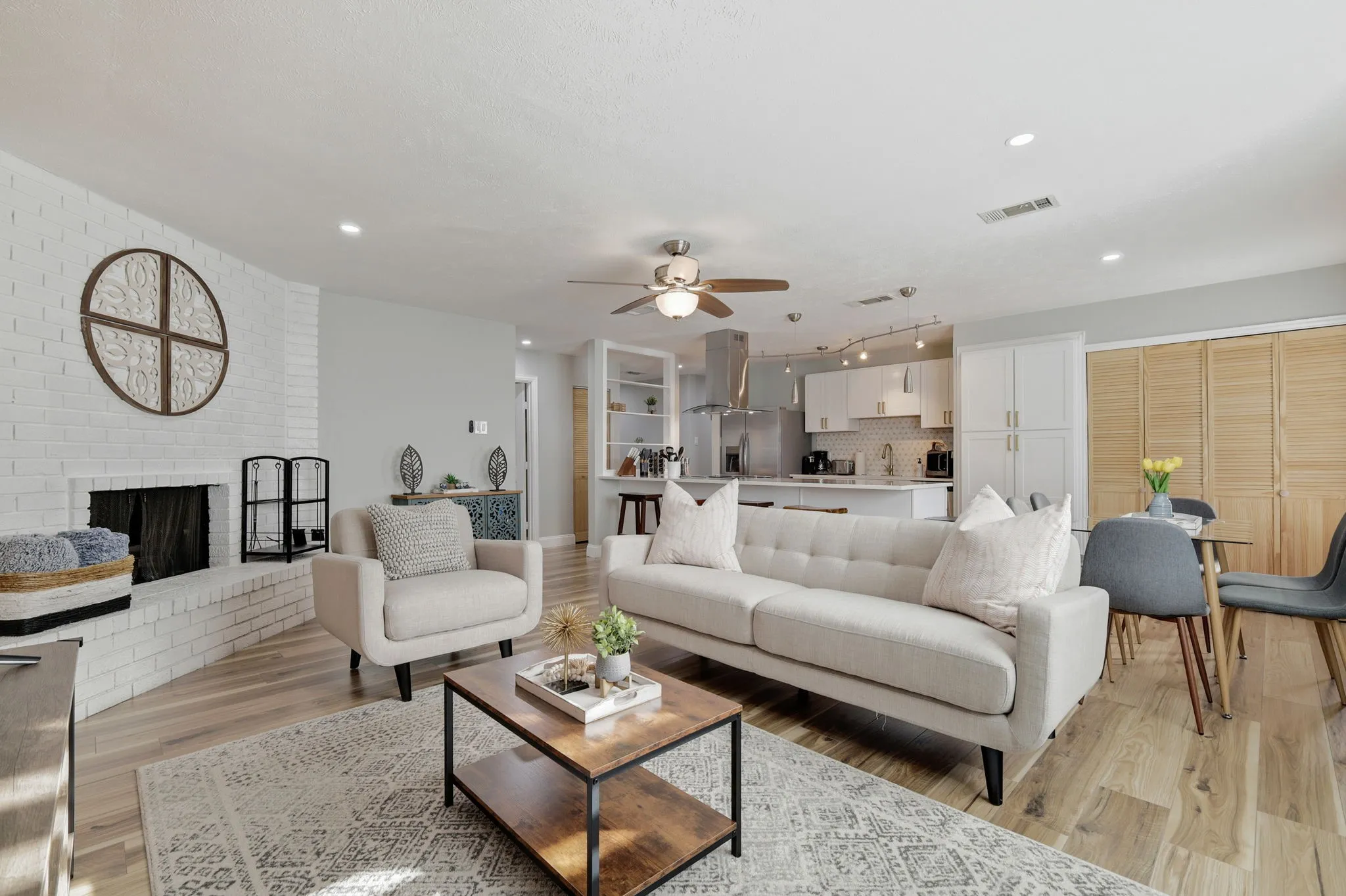Living room featuring ceiling fan, light hardwood / wood-style floors, and a brick fireplace