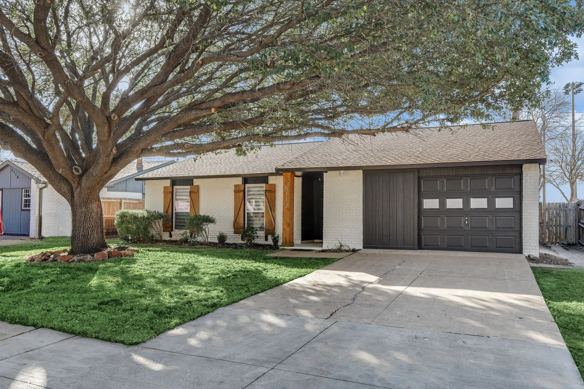 Single story home with a front yard and a garage