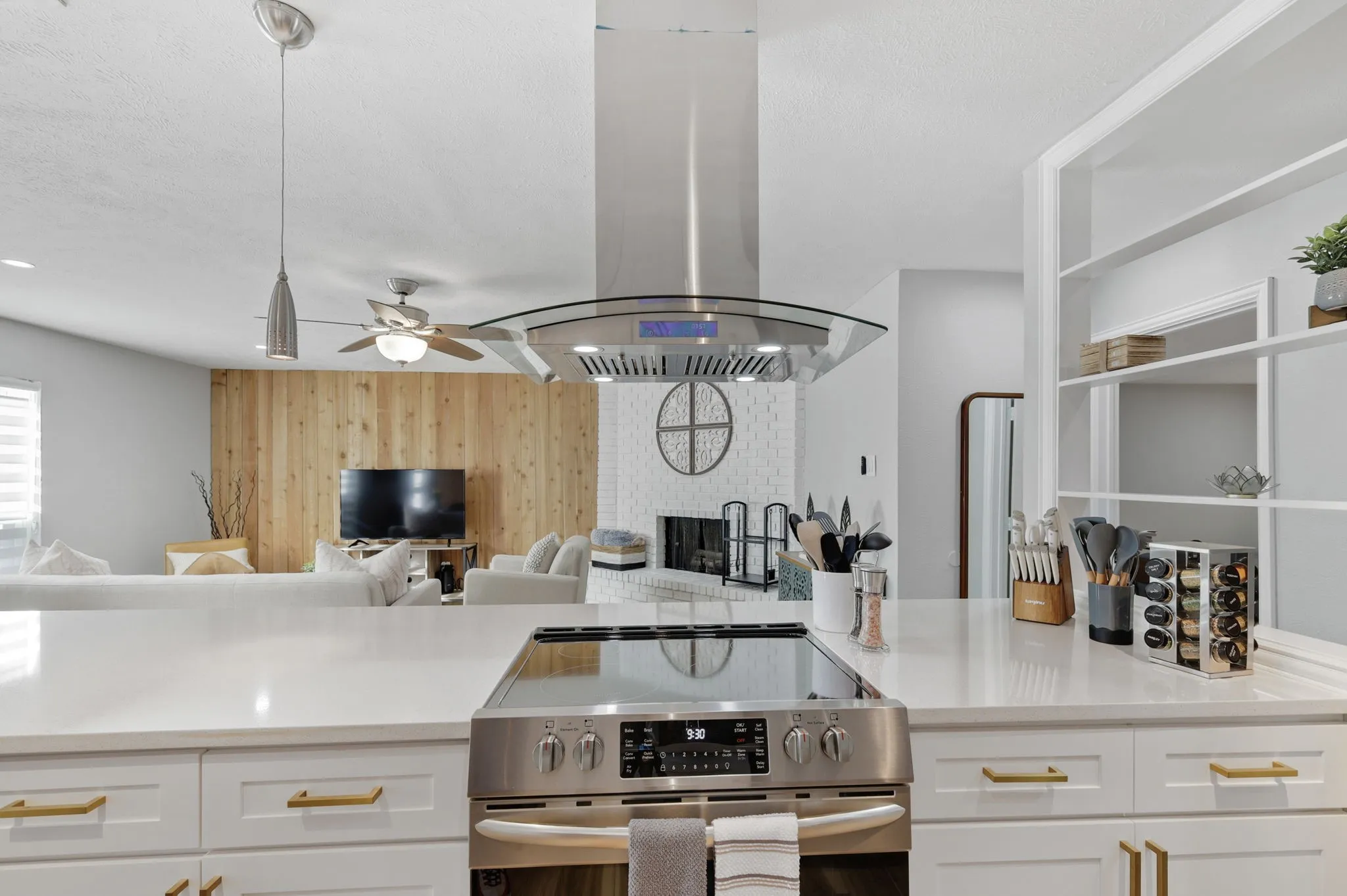 Kitchen with stainless steel range, pendant lighting, island range hood, and white cabinets