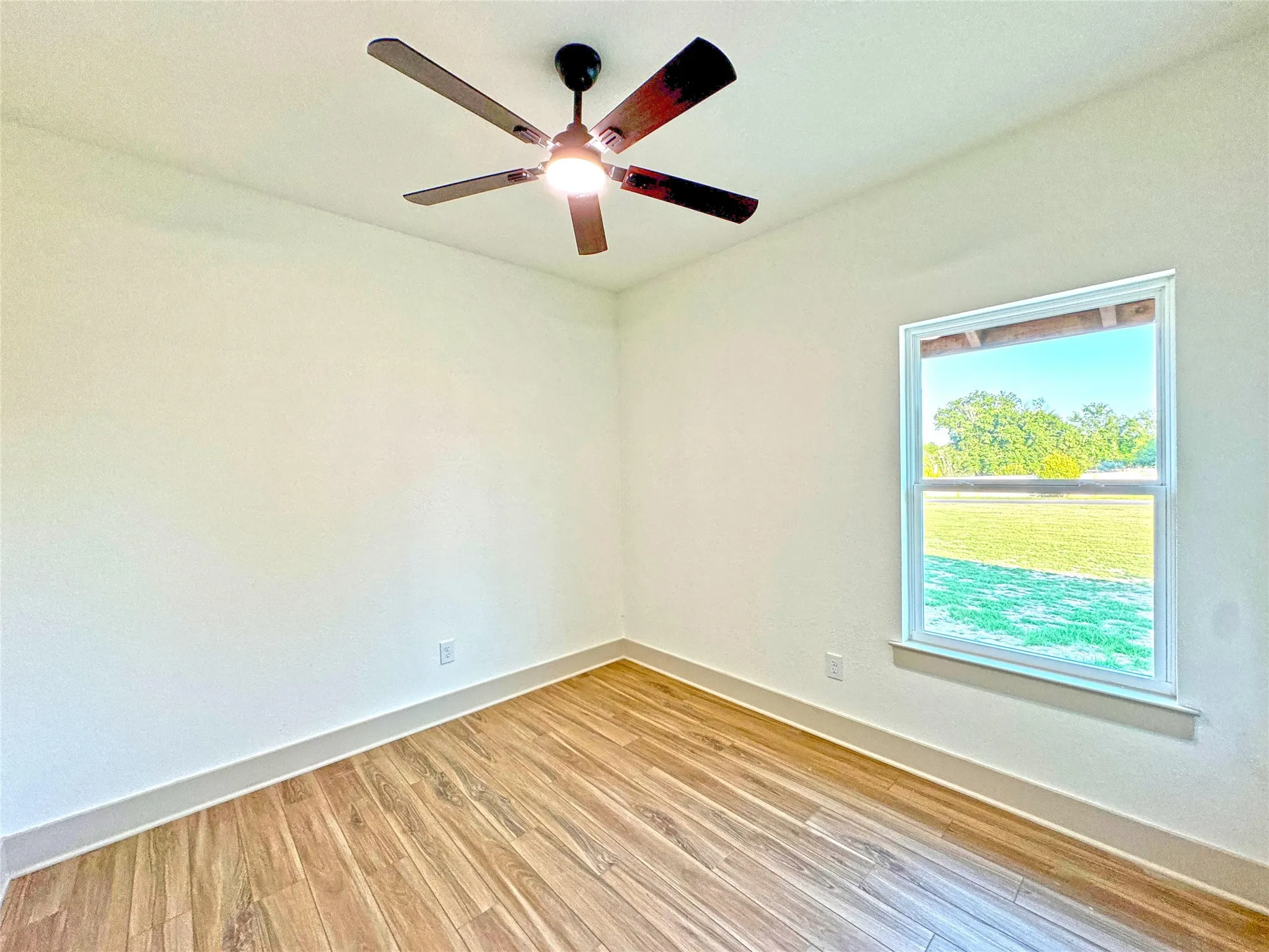 Unfurnished room with light wood-style floors and a ceiling fan