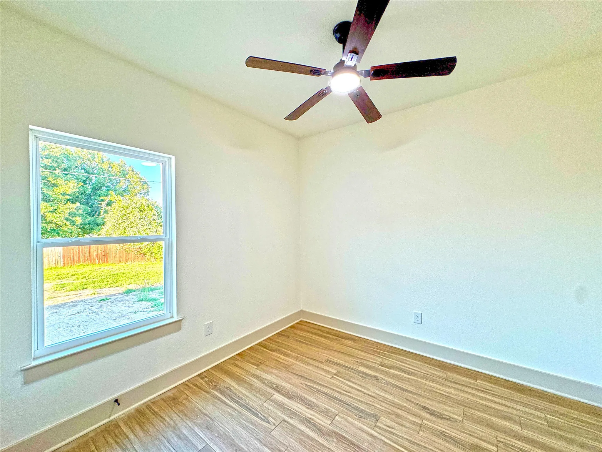 Unfurnished room with light wood-style floors and ceiling fan