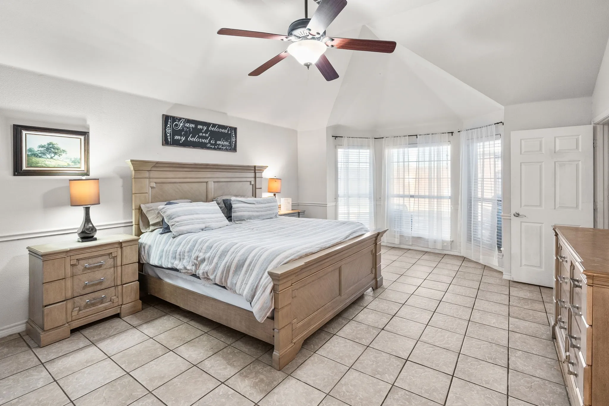 Bedroom with lofted ceiling, a ceiling fan, and light tile patterned floors