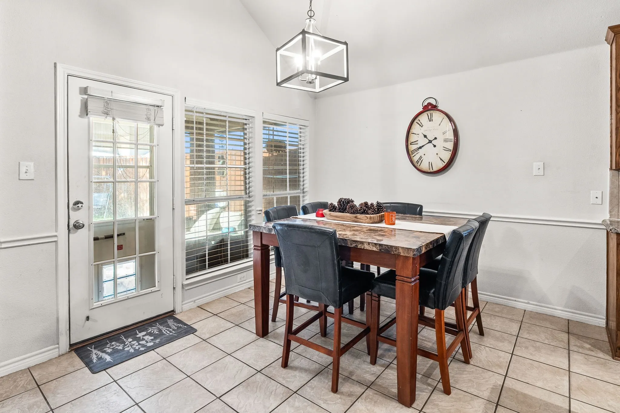 Dining space featuring light tile patterned floors and lofted ceiling