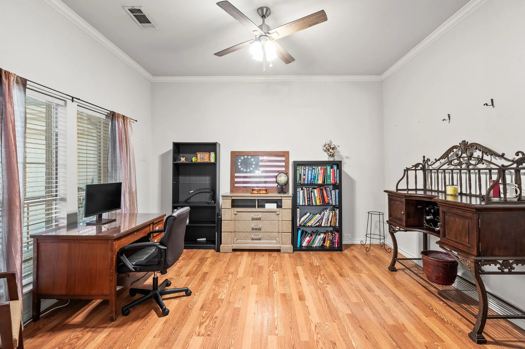 Office space featuring light wood-style floors, ornamental molding, and a ceiling fan