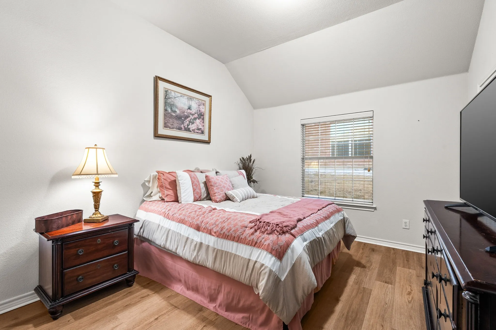 Bedroom with vaulted ceiling and light wood-type flooring