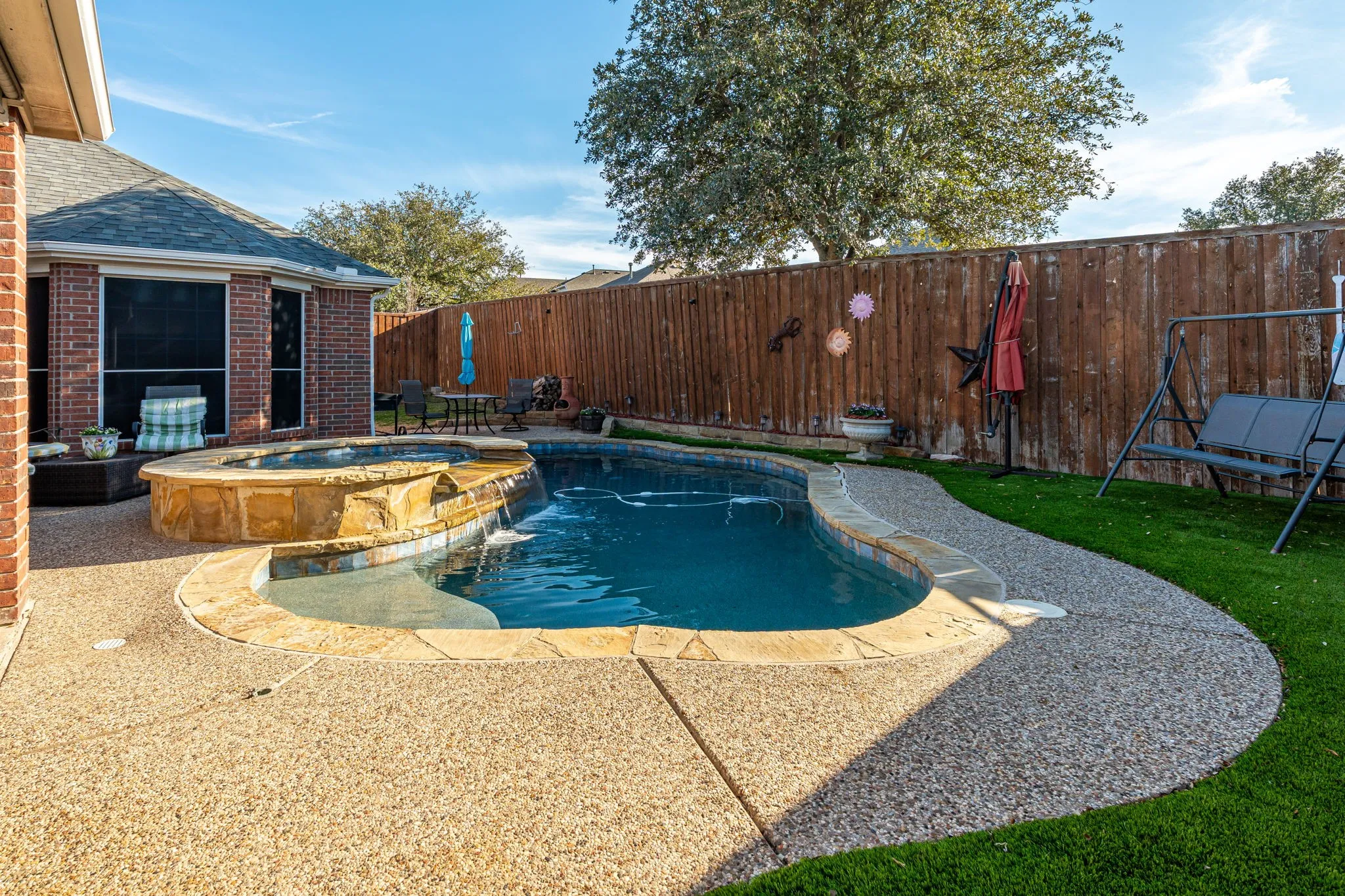 Integrated pool / hot tub featuring a fenced backyard and a patio area
