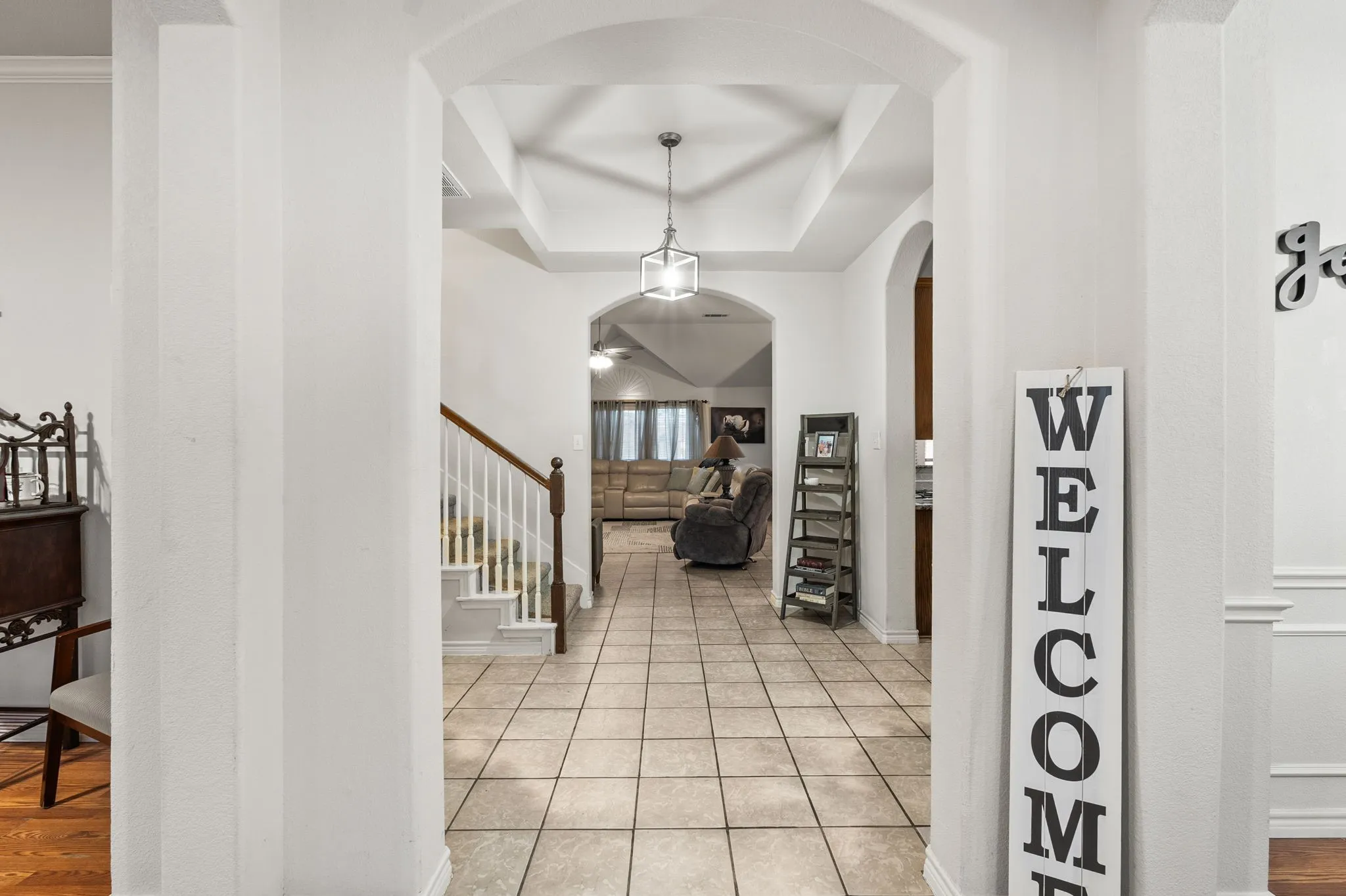 Entrance foyer with a tray ceiling and arched walkways