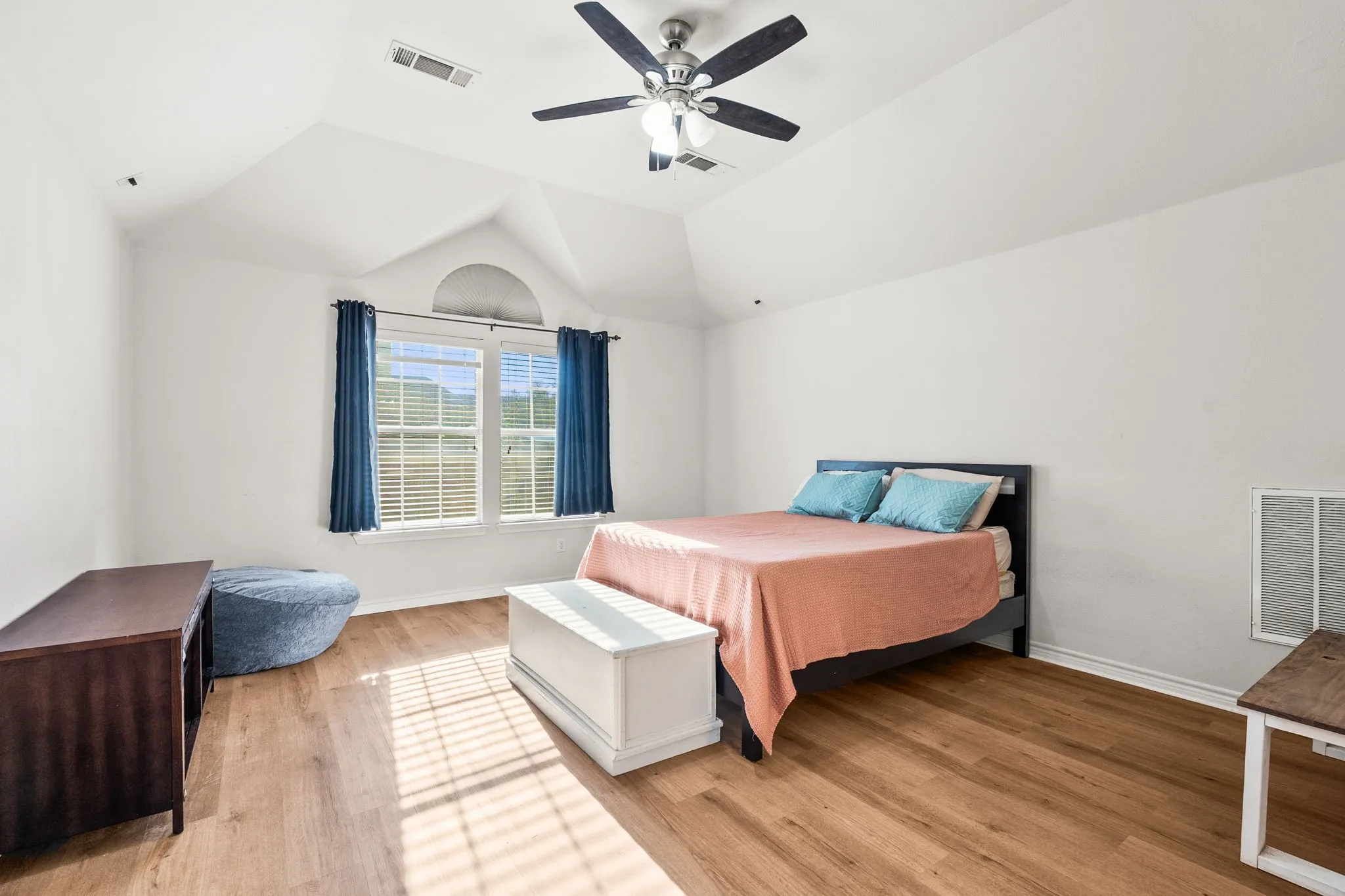 Bedroom with lofted ceiling, light wood-style flooring, and ceiling fan