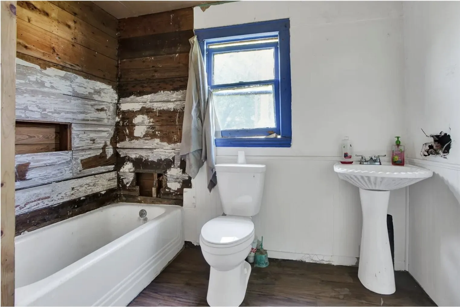Bathroom with wood walls and dark wood-style floors