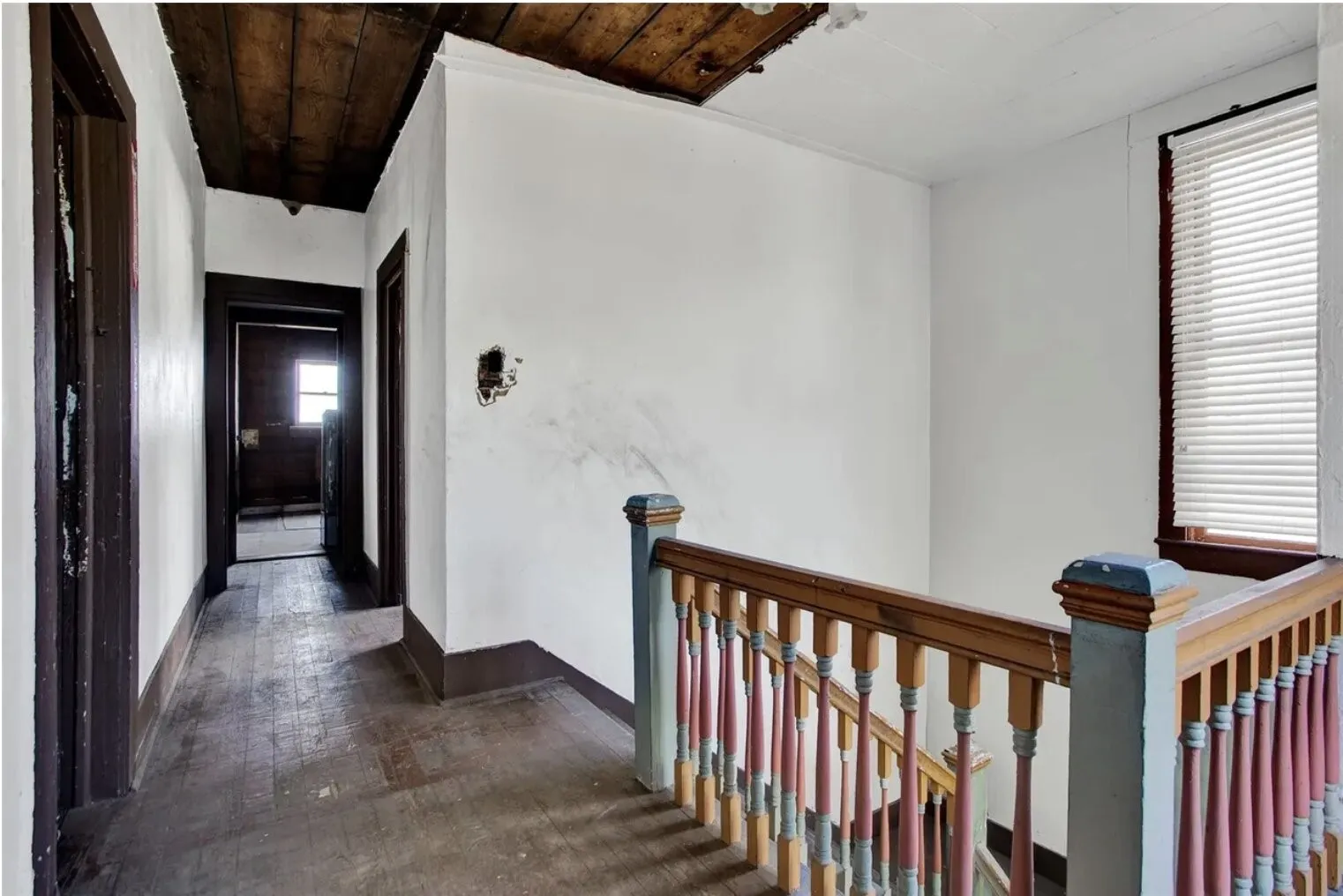 Corridor with an upstairs landing, dark wood-style floors, and wood ceiling