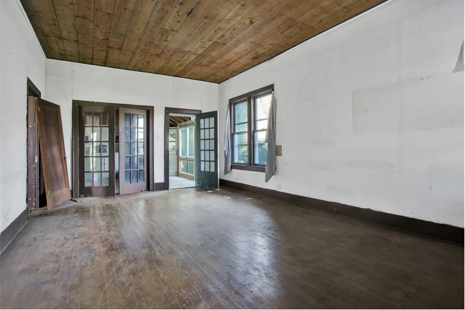 Unfurnished room featuring dark wood-style floors, wood ceiling, and french doors