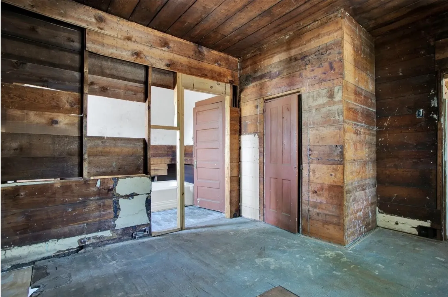 Misc room with wood walls, wooden ceiling, and concrete floors