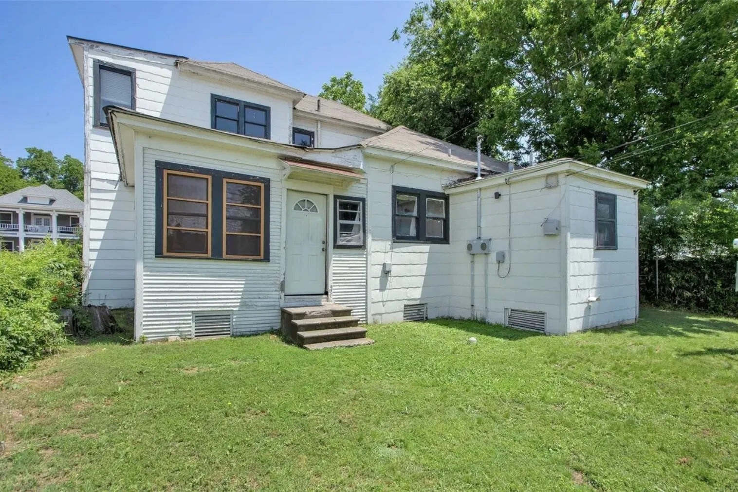 View of front of property with a front yard and entry steps