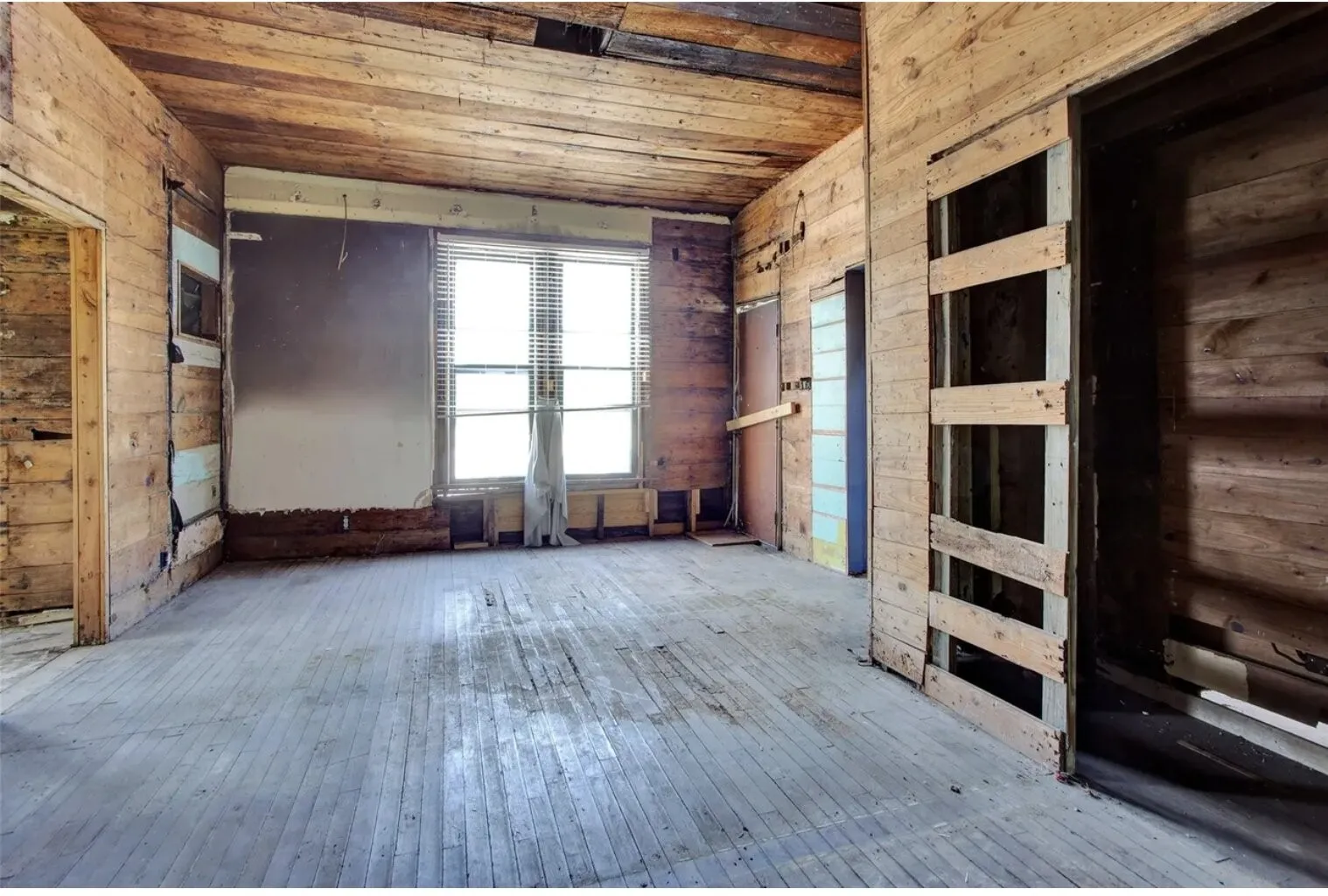 Empty room with wooden walls, wood ceiling, and wood-type flooring
