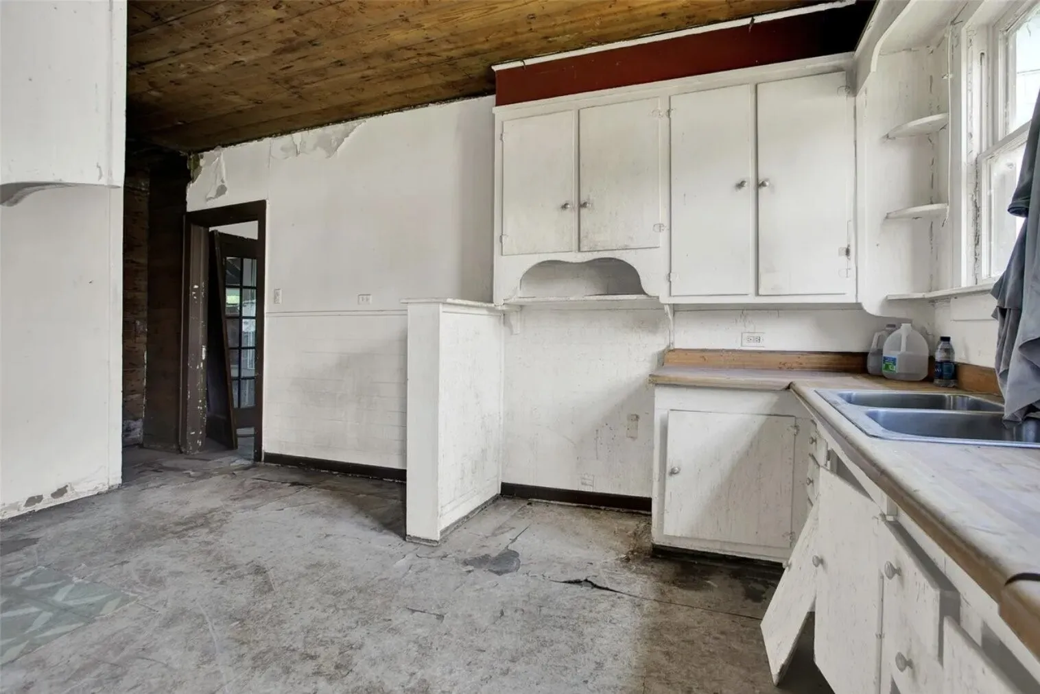 Kitchen featuring white cabinetry, open shelves, light countertops, and concrete floors