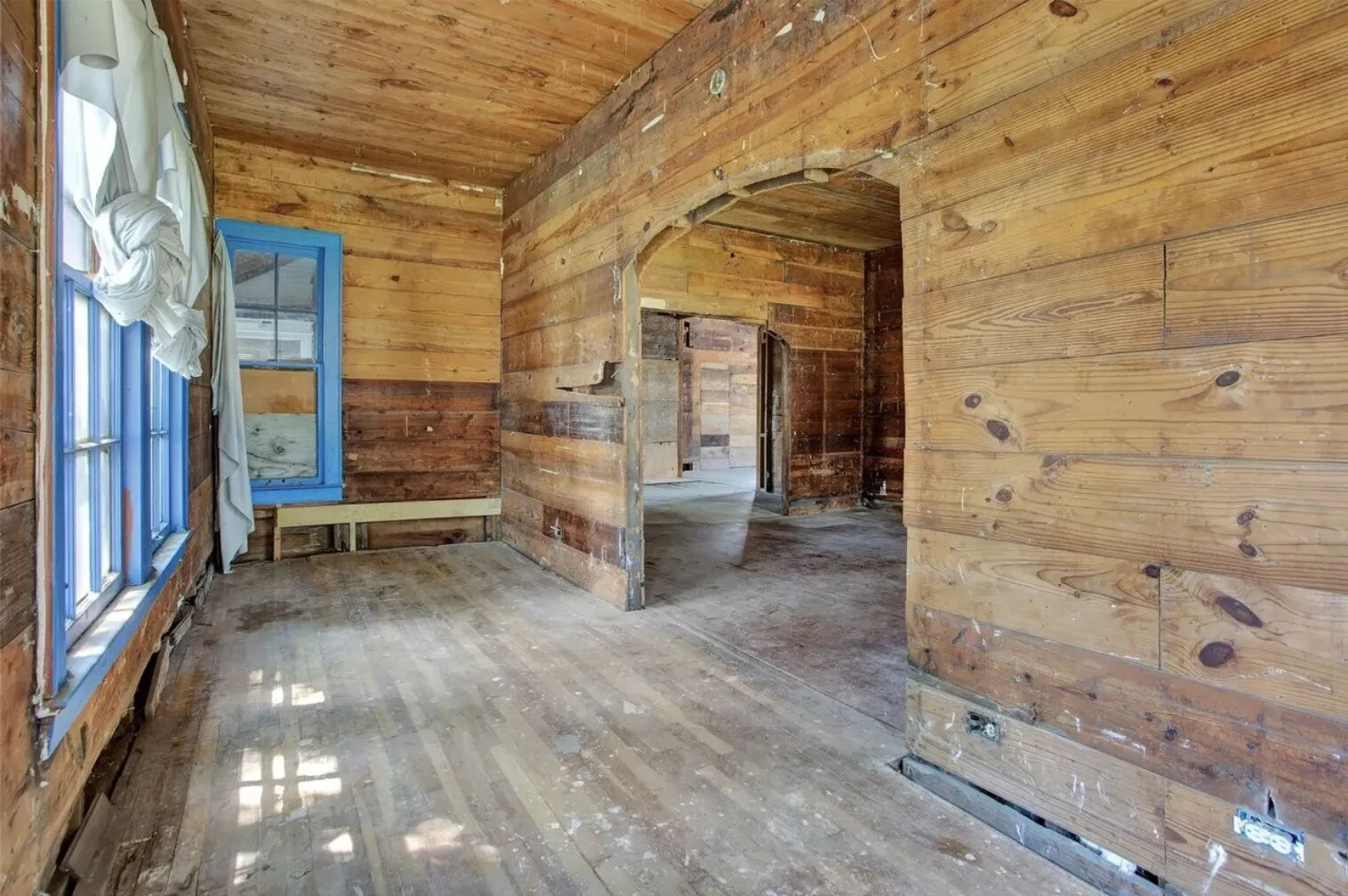 Spare room featuring arched walkways, wooden walls, wood ceiling, and hardwood / wood-style flooring