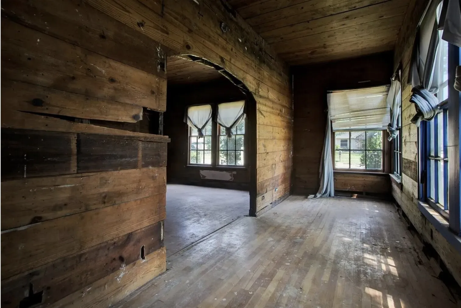 Unfurnished room featuring wood ceiling, healthy amount of natural light, wooden walls, and wood-type flooring