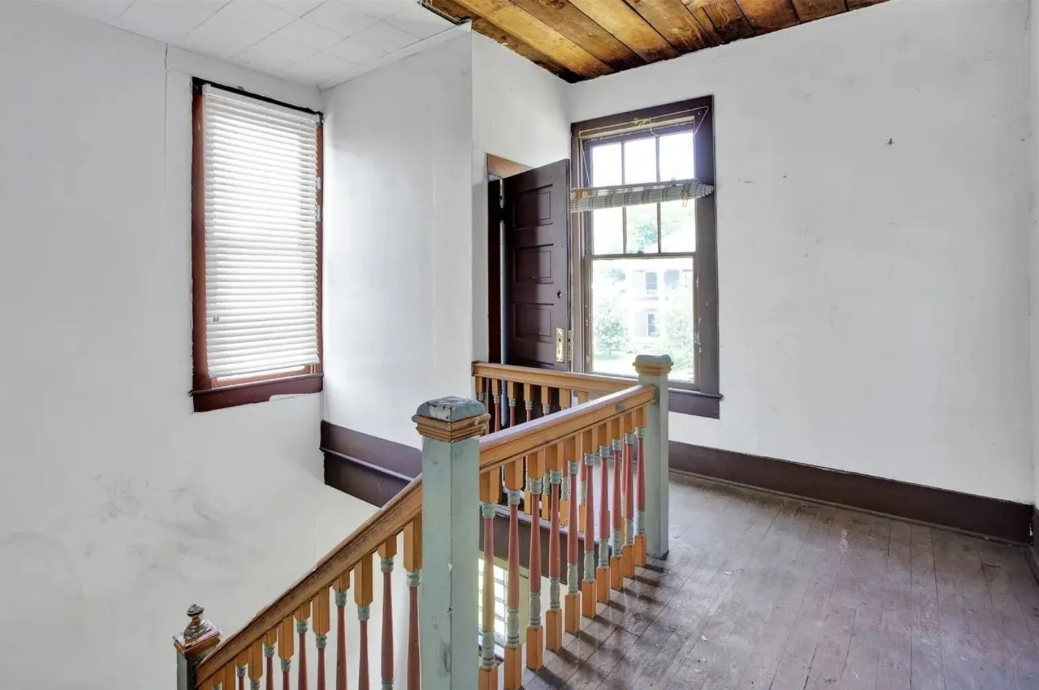 Hallway featuring wood-type flooring and an upstairs landing