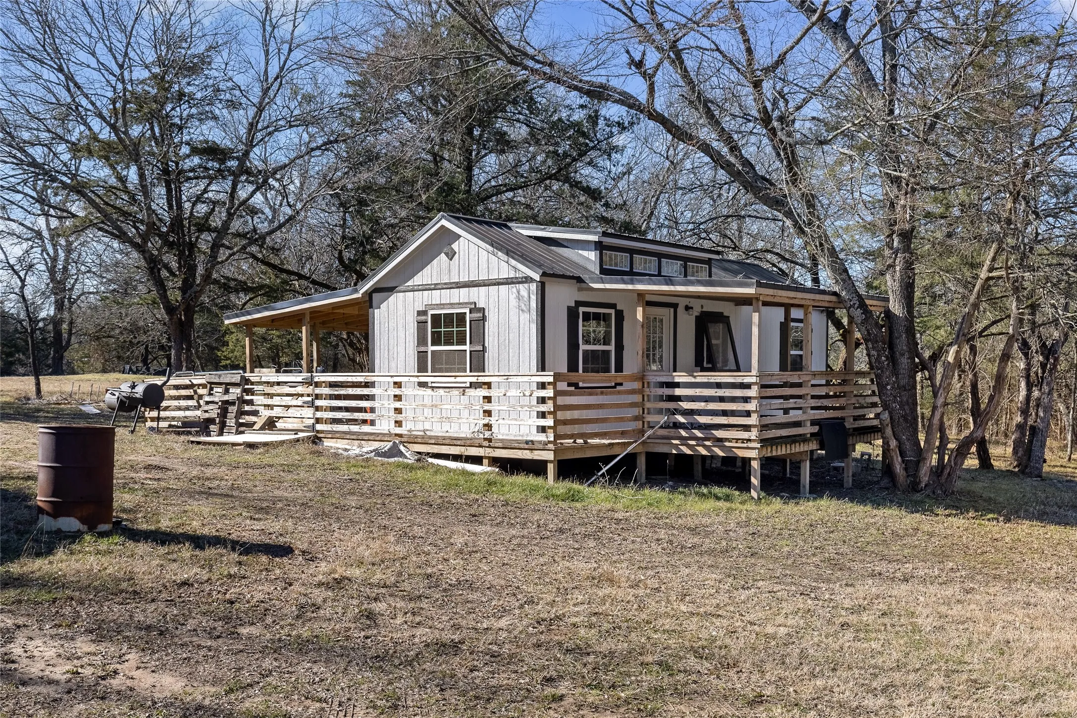 View of front of home featuring a porch, a metal roof, and view of scattered trees
