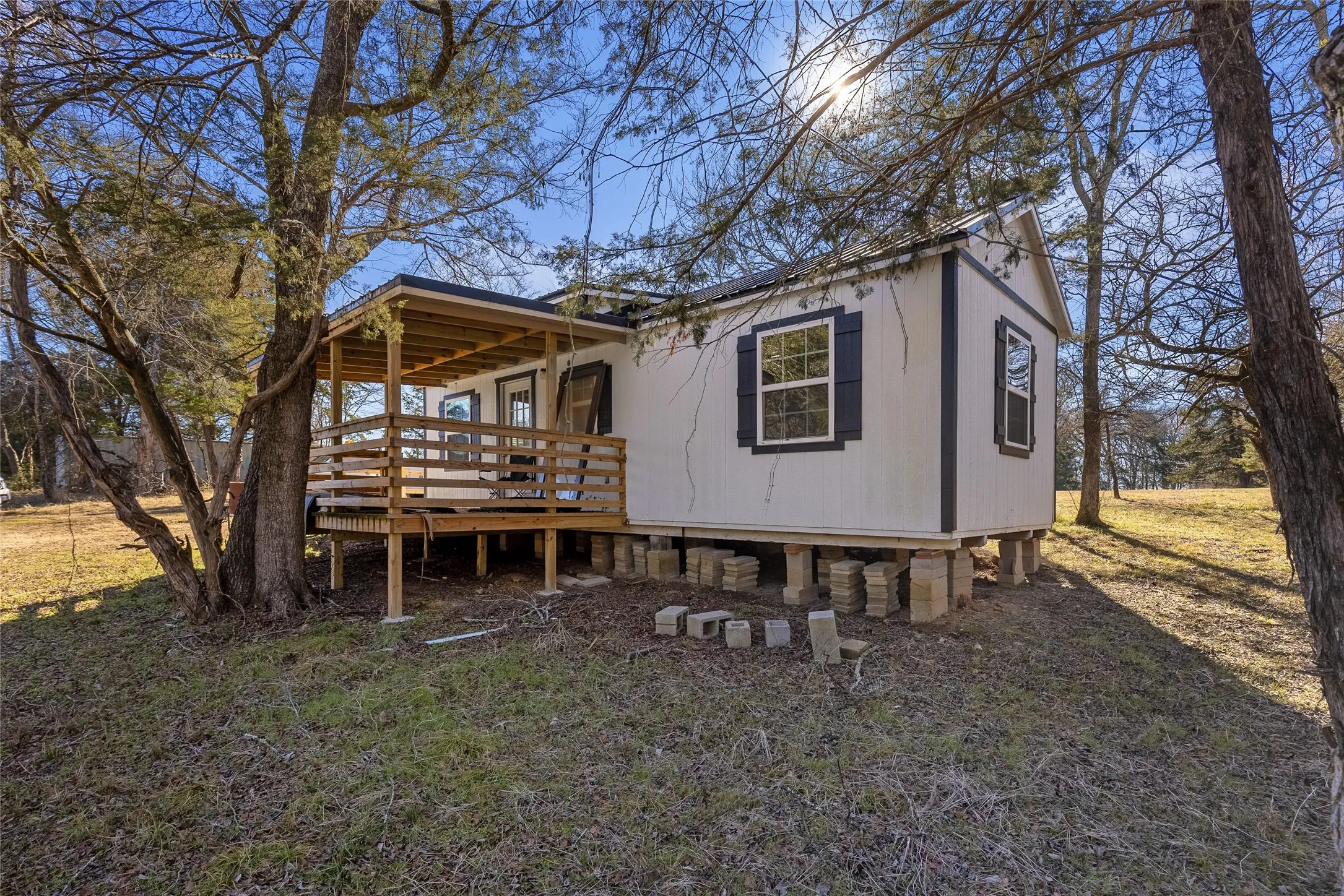 Rear view of house with a deck and a lawn