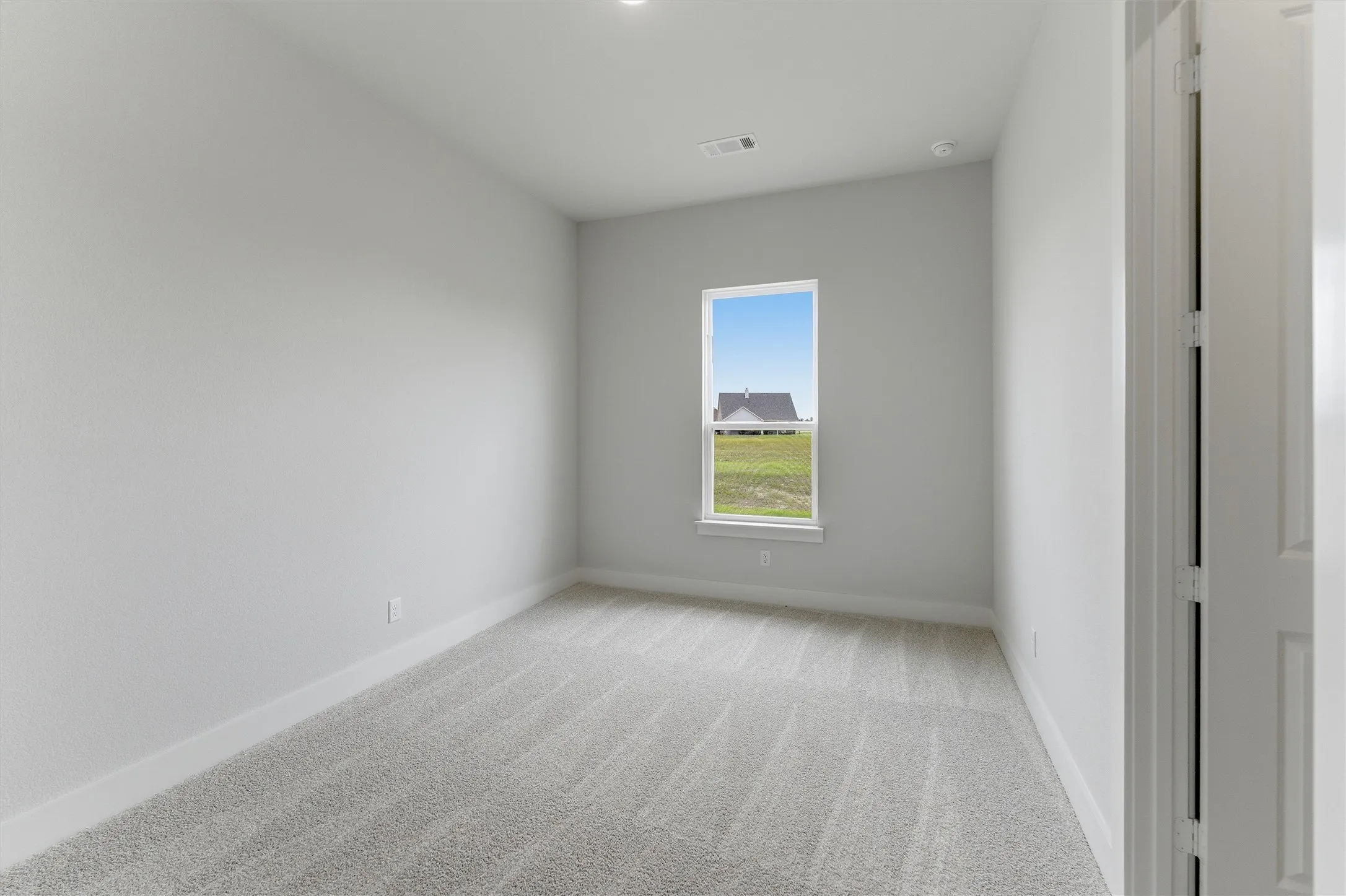 Carpeted interior room with white walls, baseboards, and ceiling