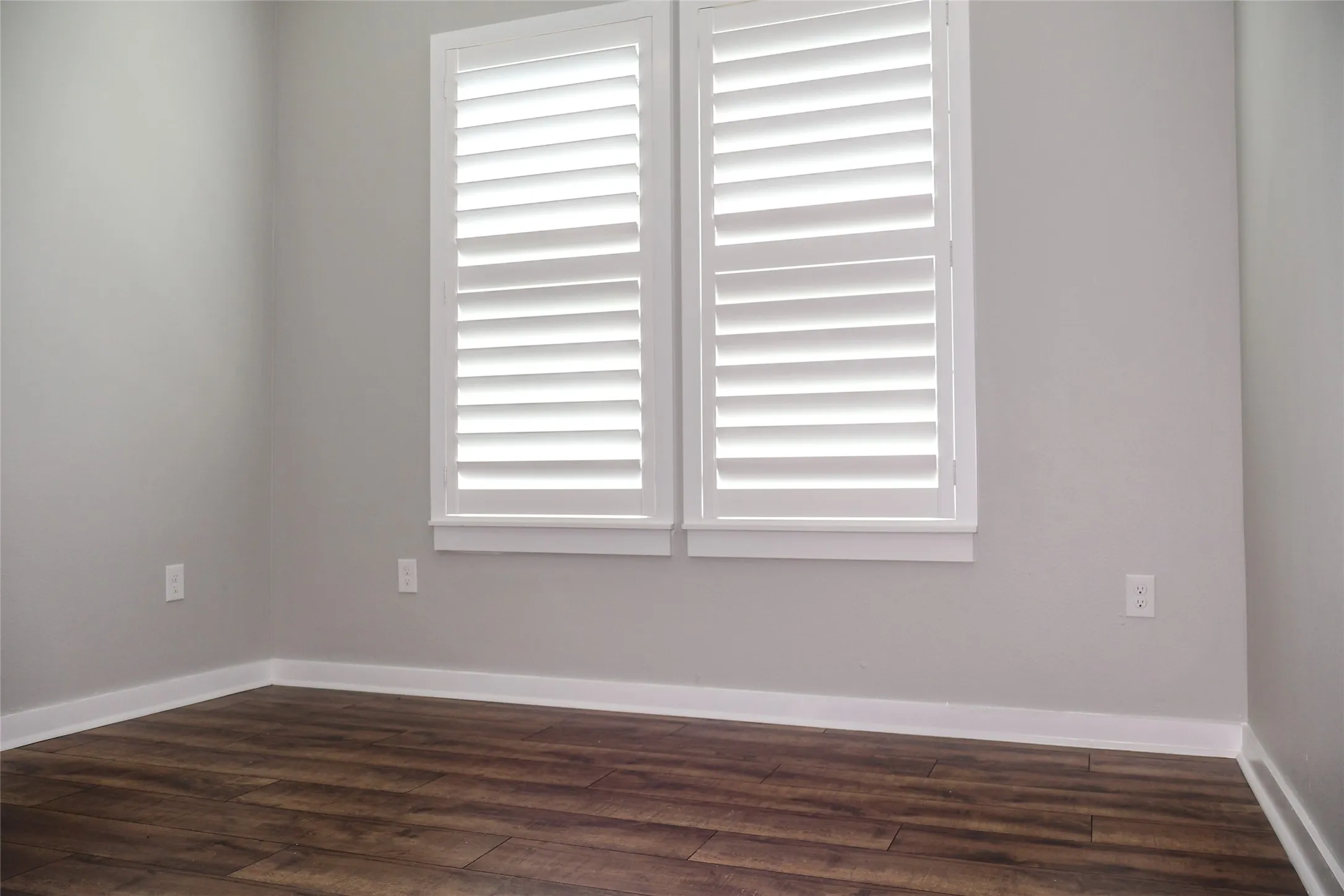 Unfurnished room with dark wood-style floors and baseboards