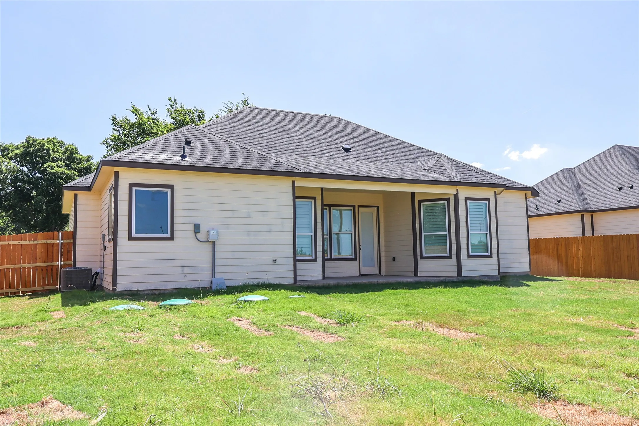 Rear view of house featuring a patio and a shingled roof