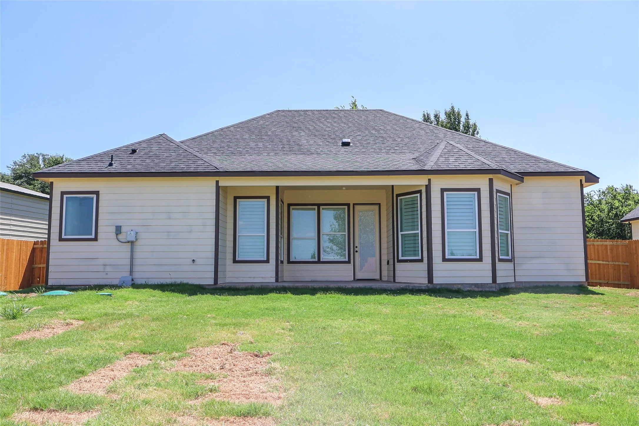Rear view of property featuring a patio area and roof with shingles