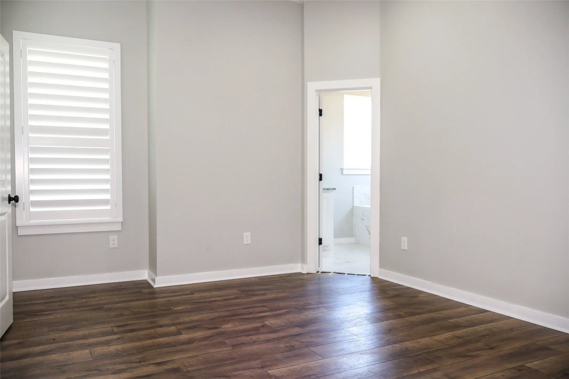 Spare room with dark wood finished floors and baseboards