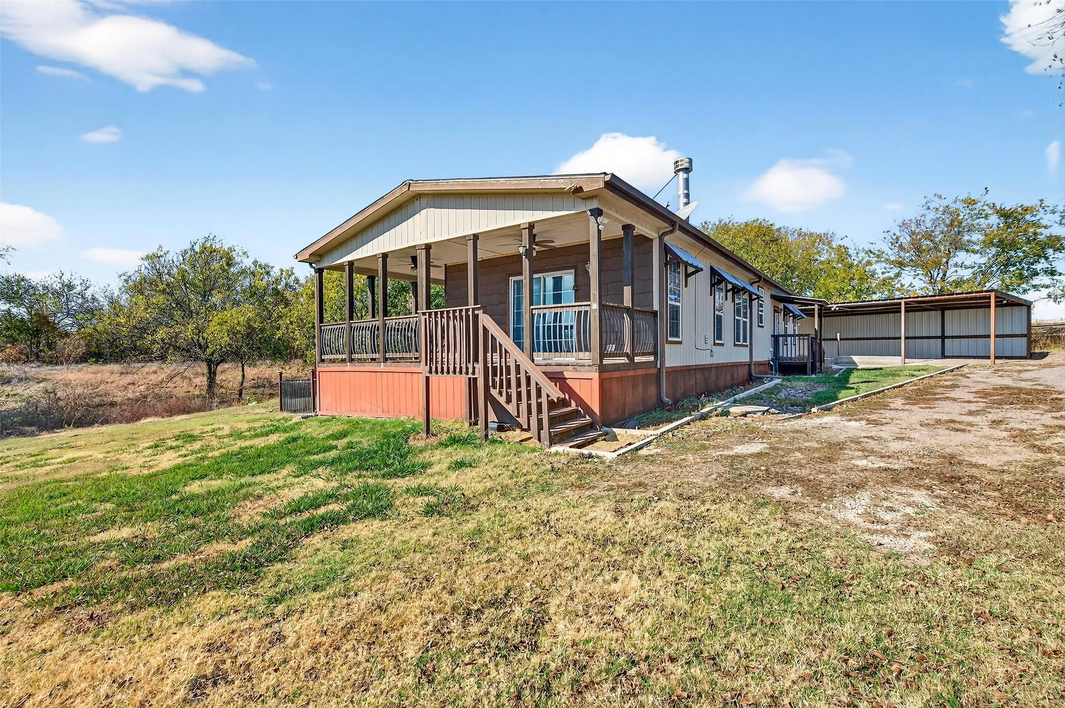 Back of property with a ceiling fan, a lawn, stairs, covered porch, and an outdoor structure