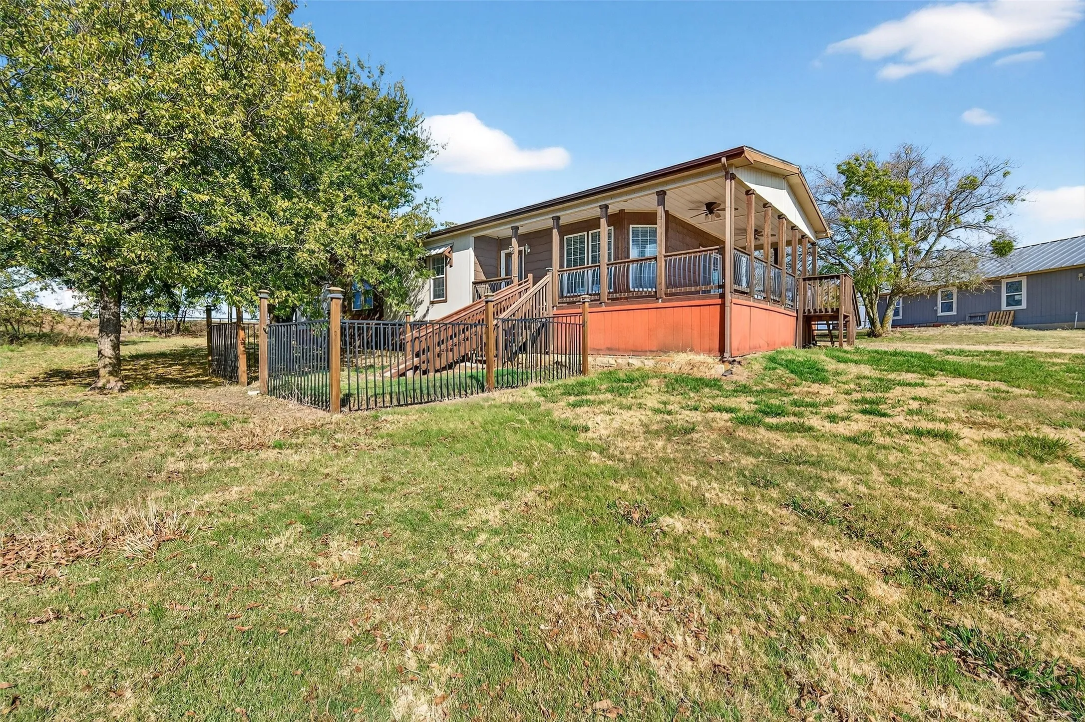 Back of property with a ceiling fan and stairway