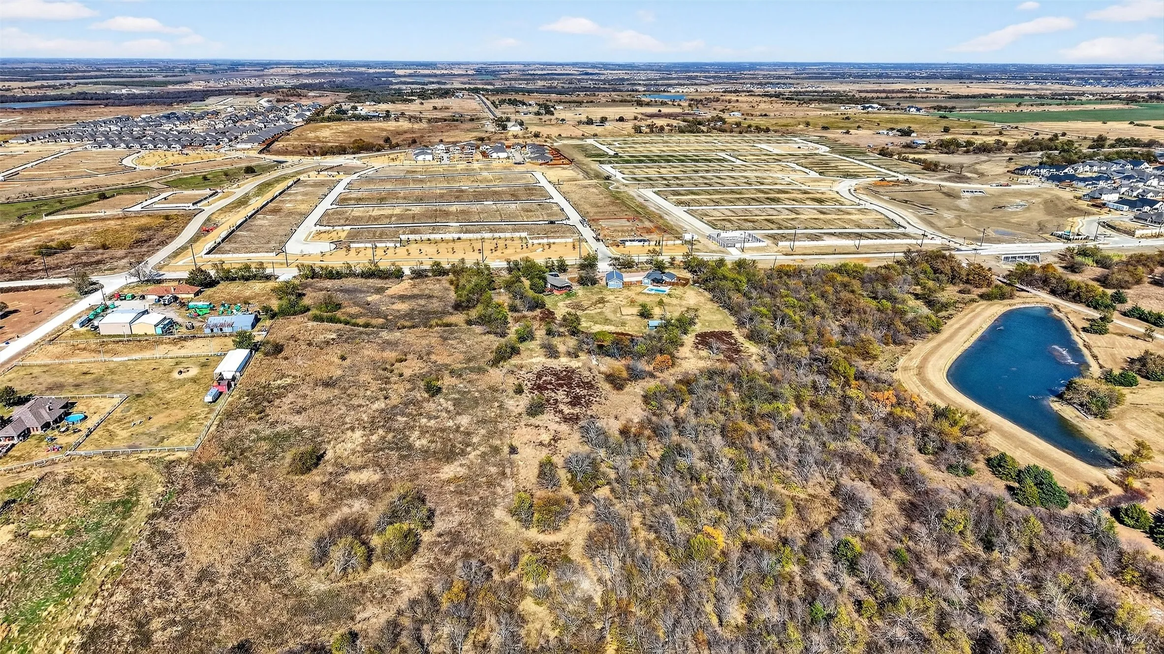 Aerial view of property and surrounding area featuring rural landscape and a large body of water