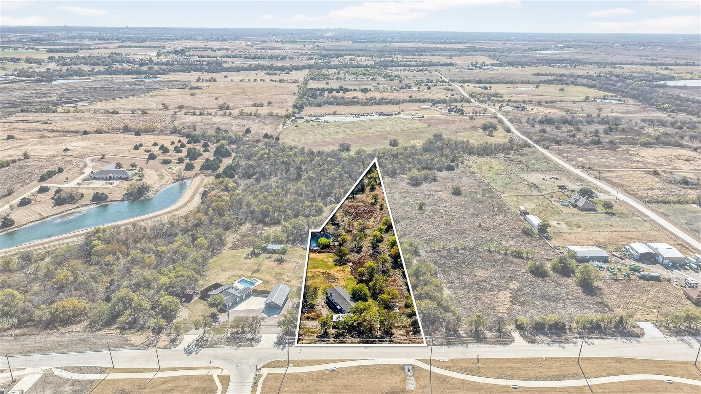 Overview of rural landscape with a nearby body of water and property boundaries highlighted
