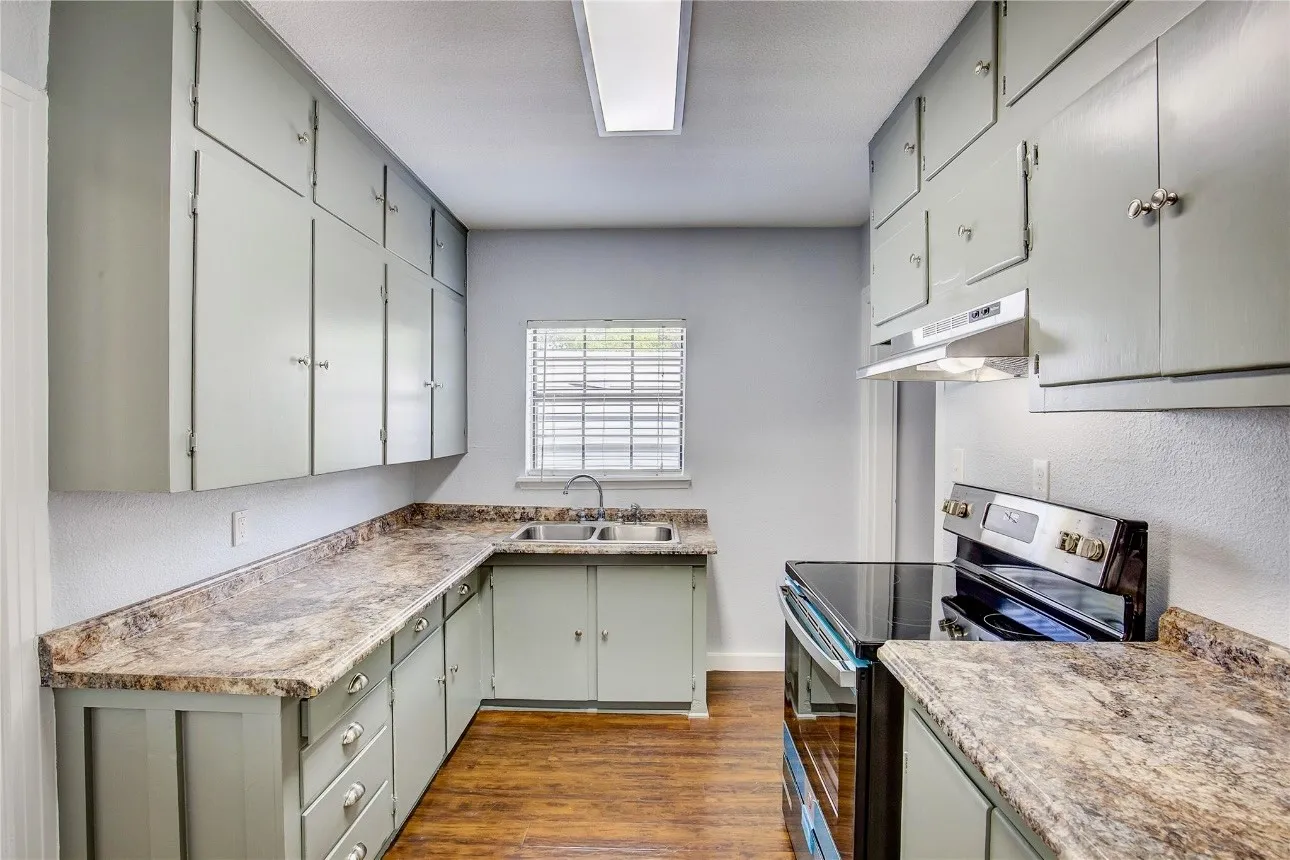 Kitchen with dark hardwood / wood-style flooring, sink, and stainless steel electric range