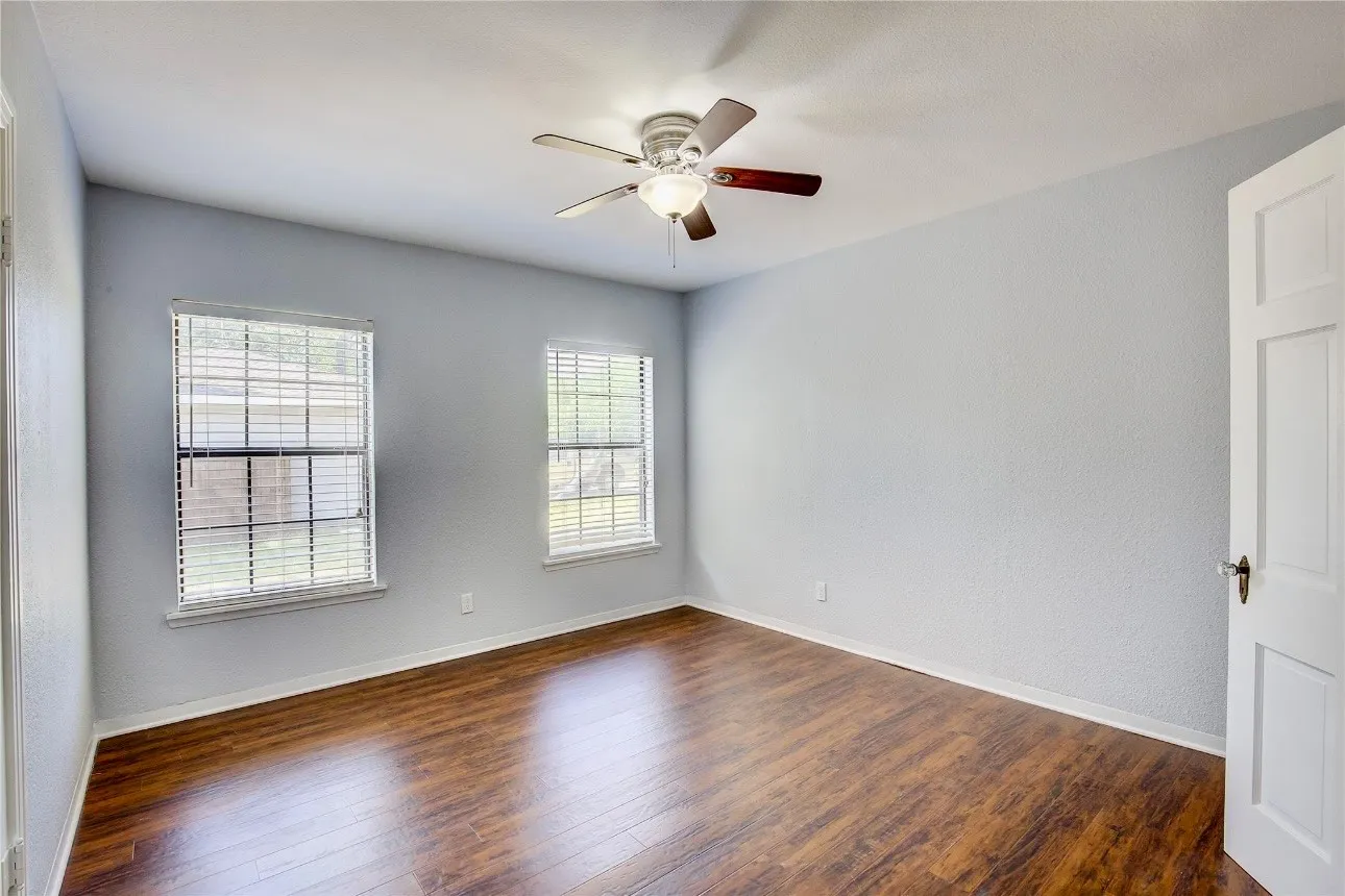 Spare room with dark hardwood / wood-style floors and ceiling fan